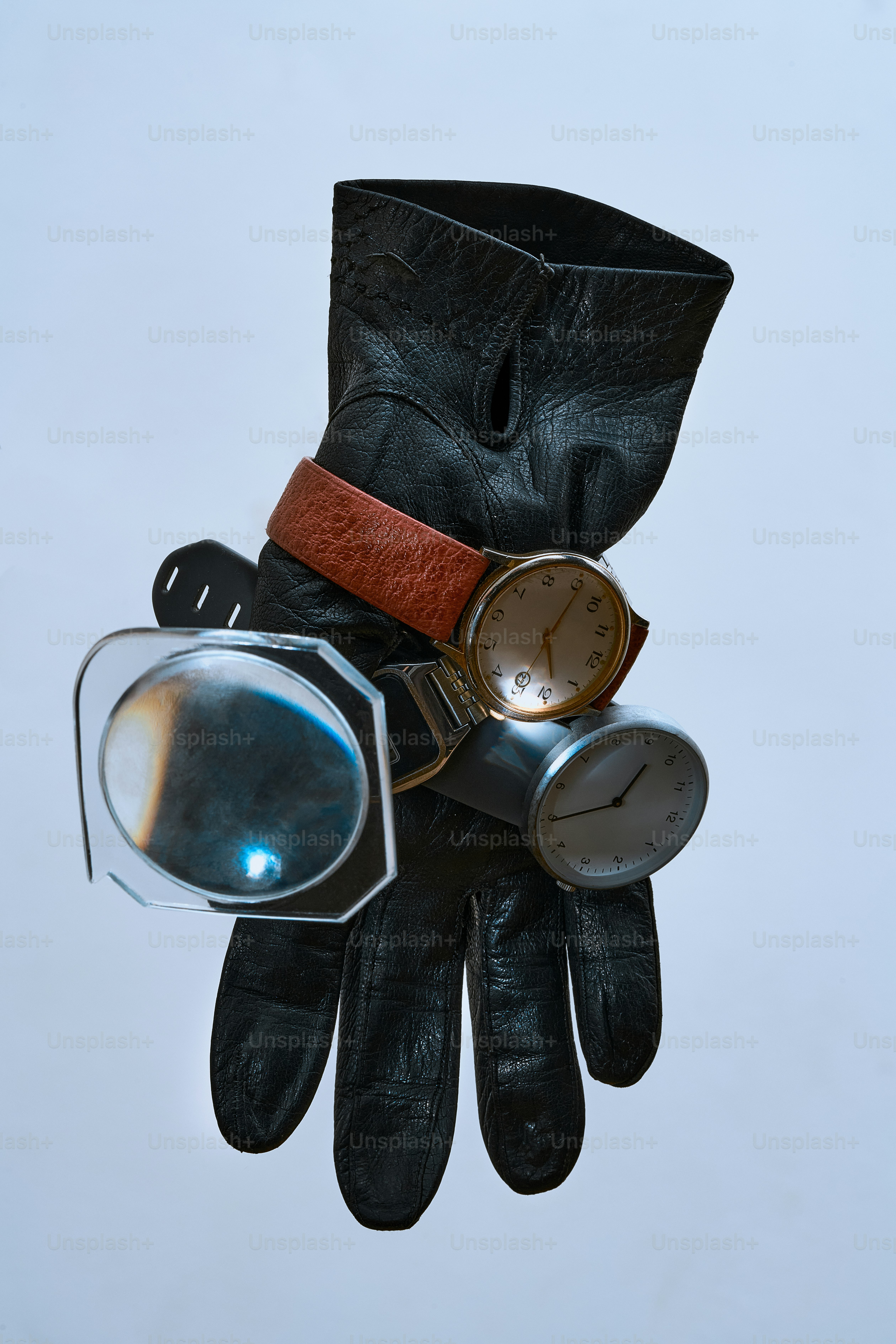 Black leather glove with two watches and magnifier.
