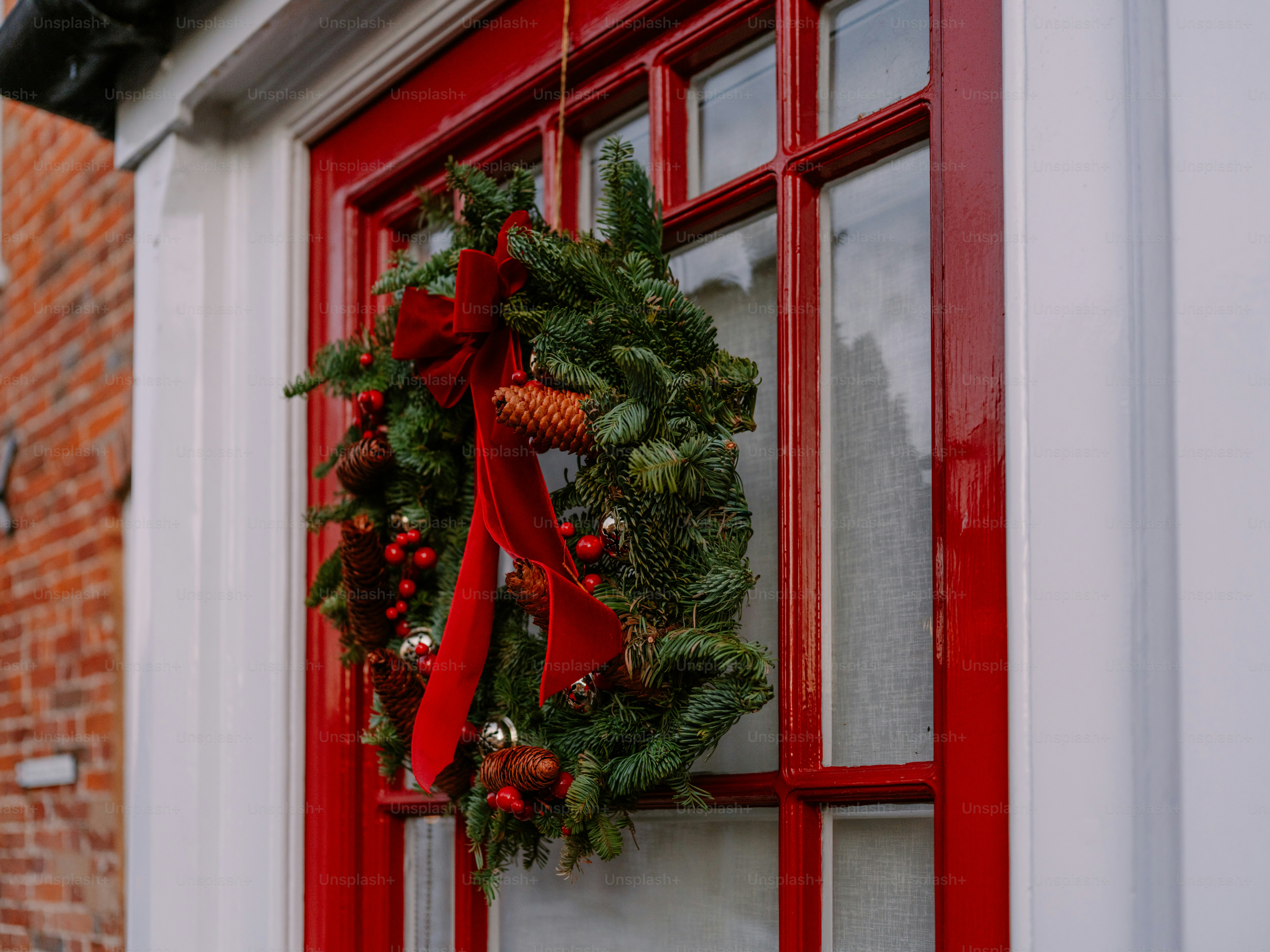 A festive christmas wreath hangs on a red door. photo – Christmas Image ...