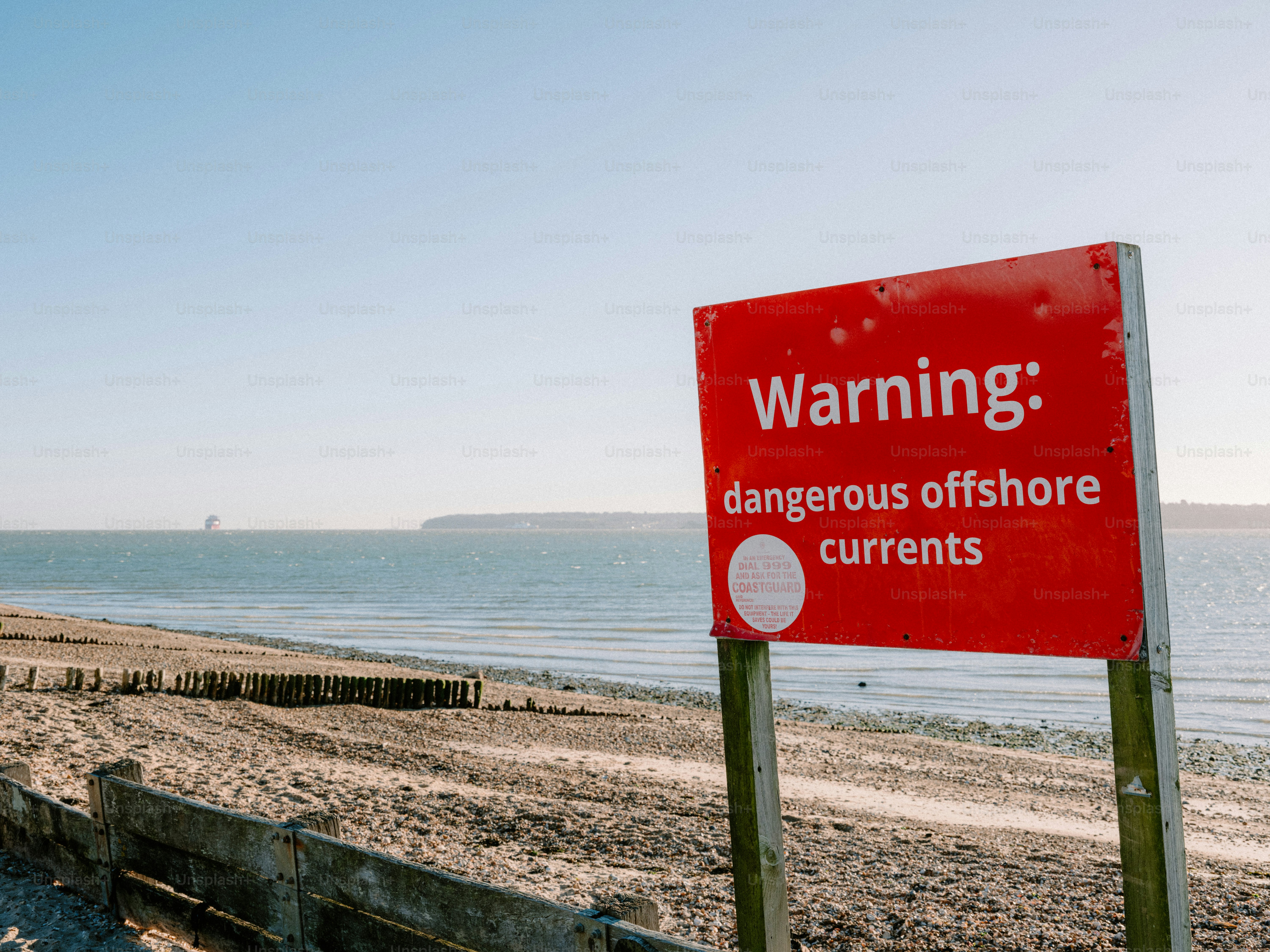 Red warning sign about dangerous offshore currents.