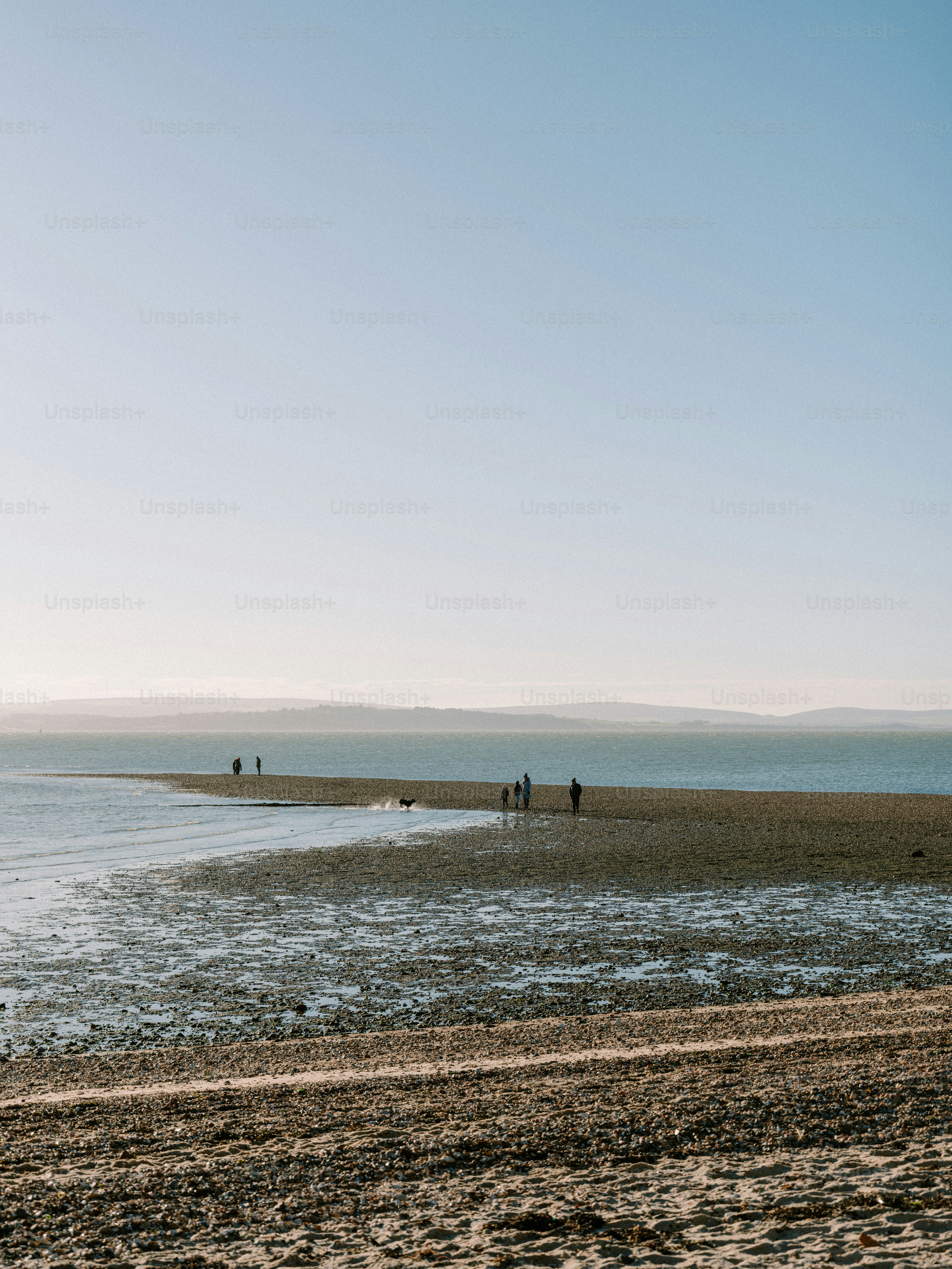 Des gens marchant sur un banc de sable à marée basse