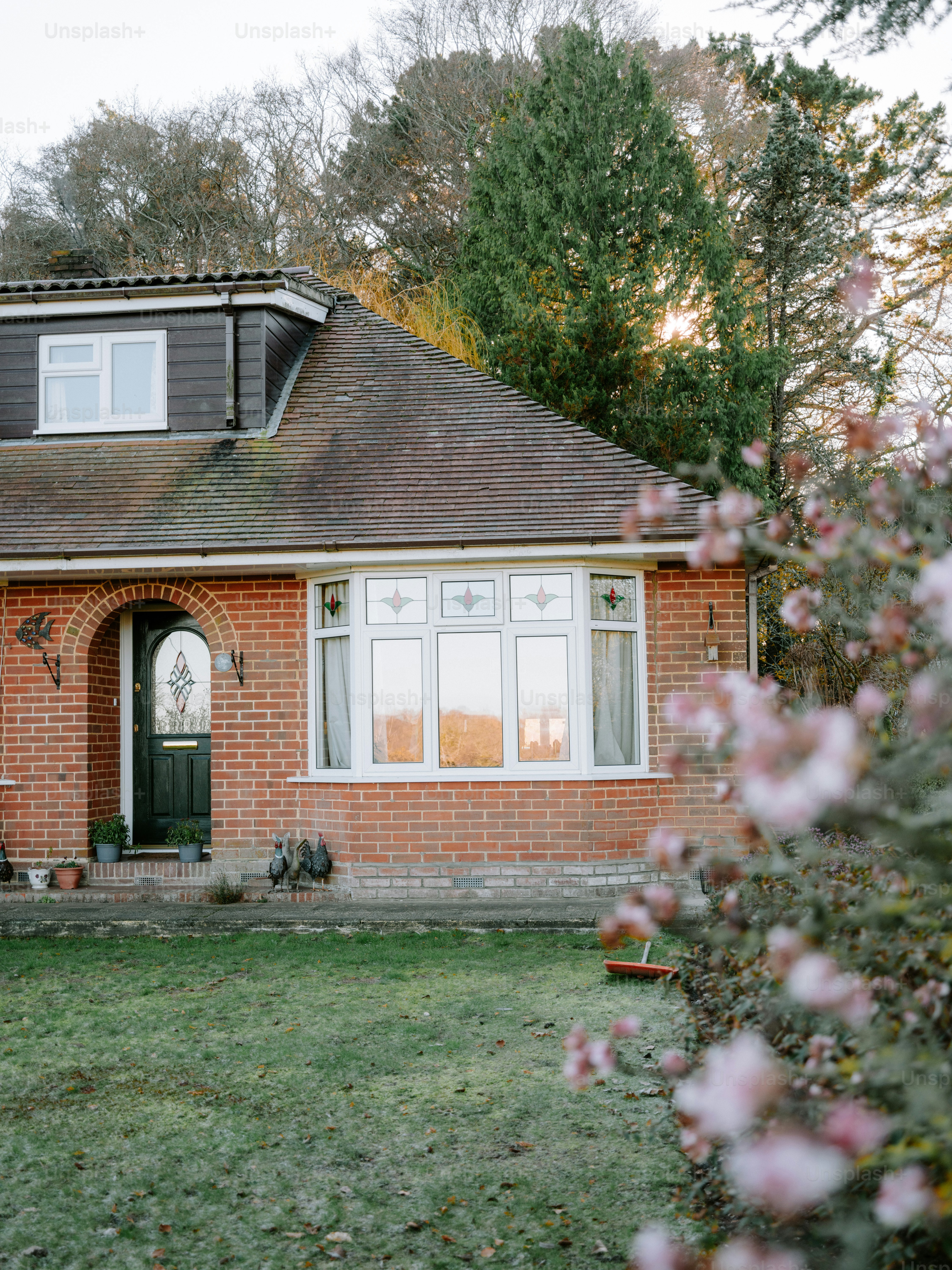 Brick house with a green lawn and flowering tree
