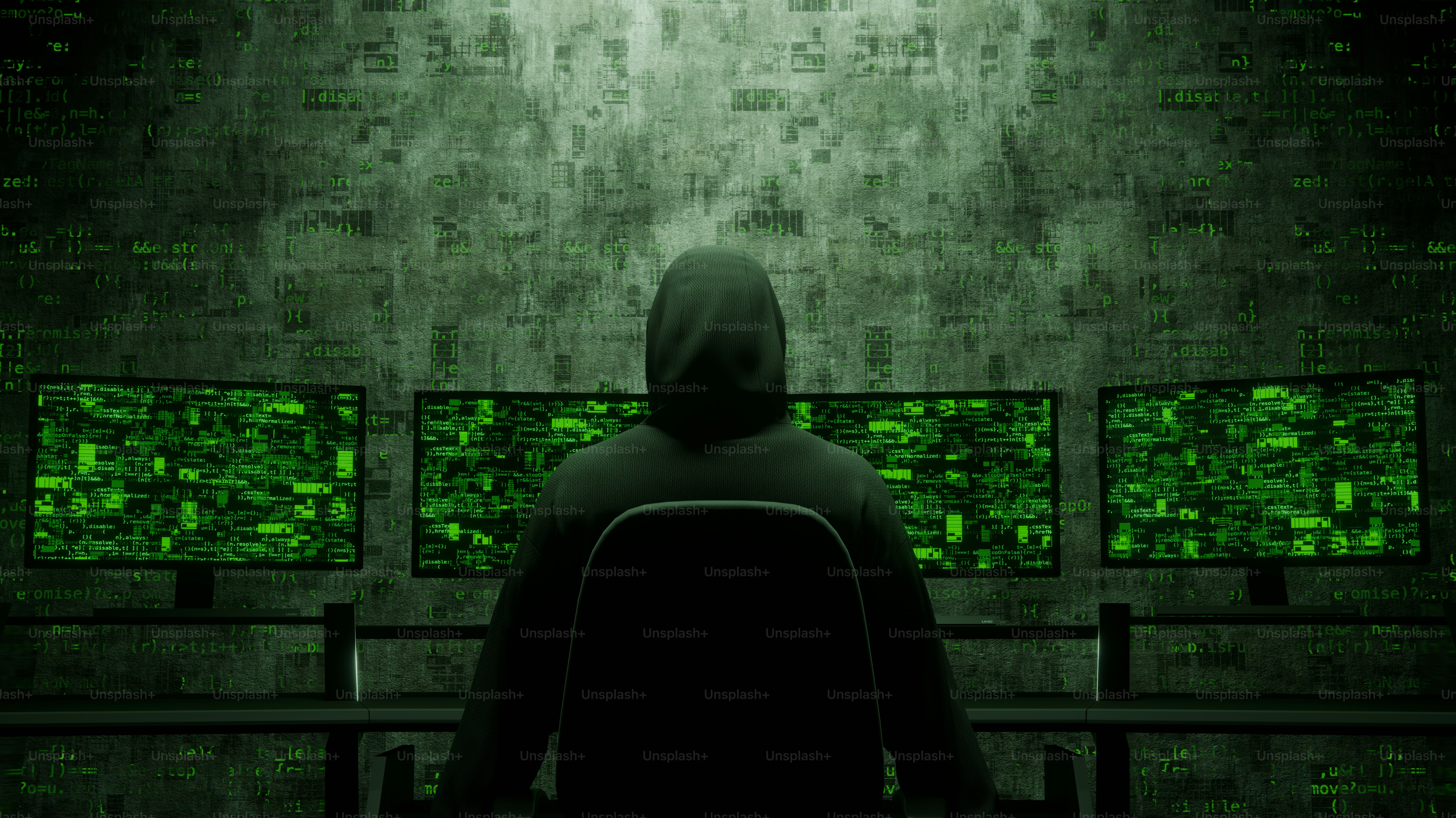 Hacker con felpa guarda gli schermi con codice