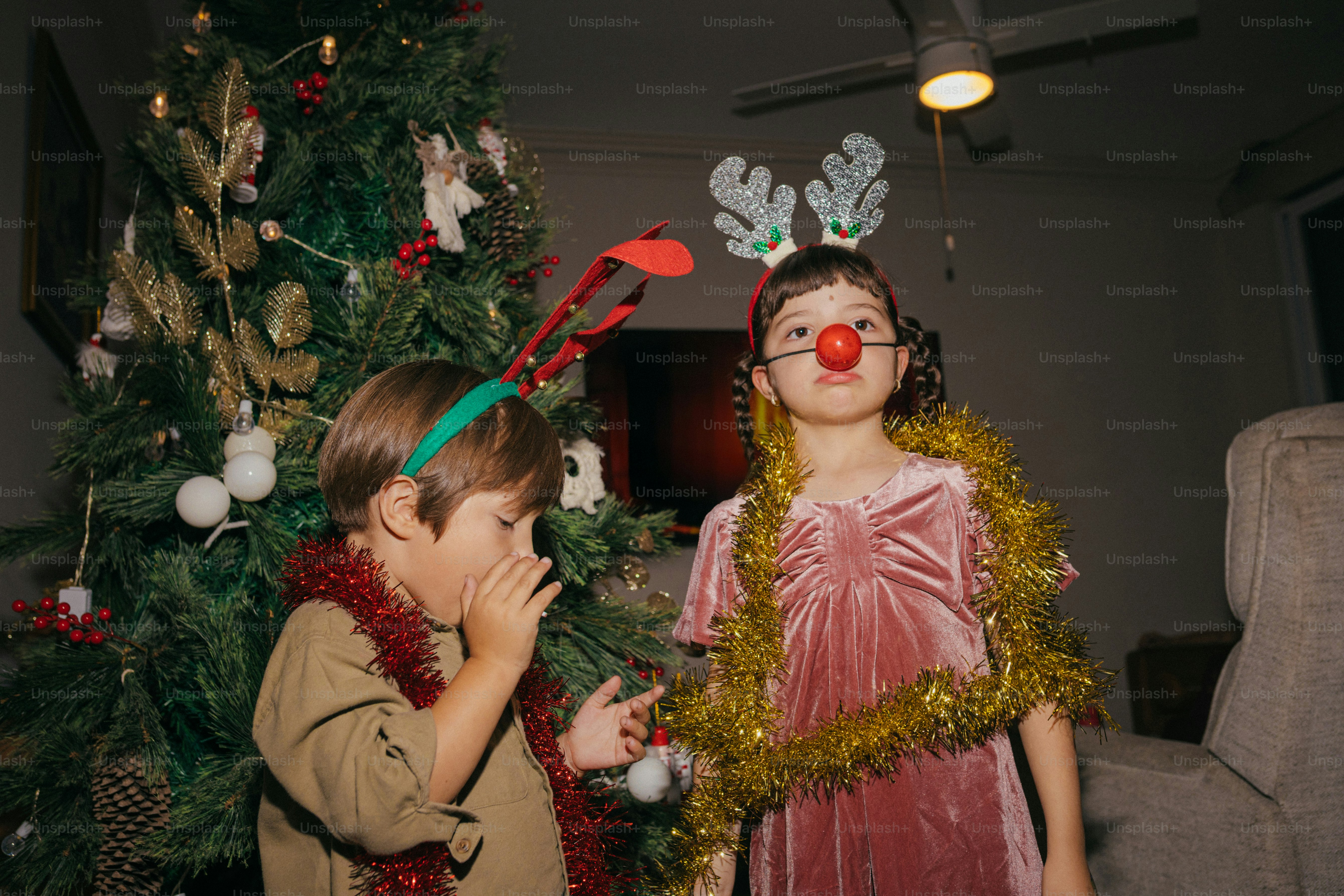 Kinder in festlicher Kleidung bei einem Weihnachtsbaum