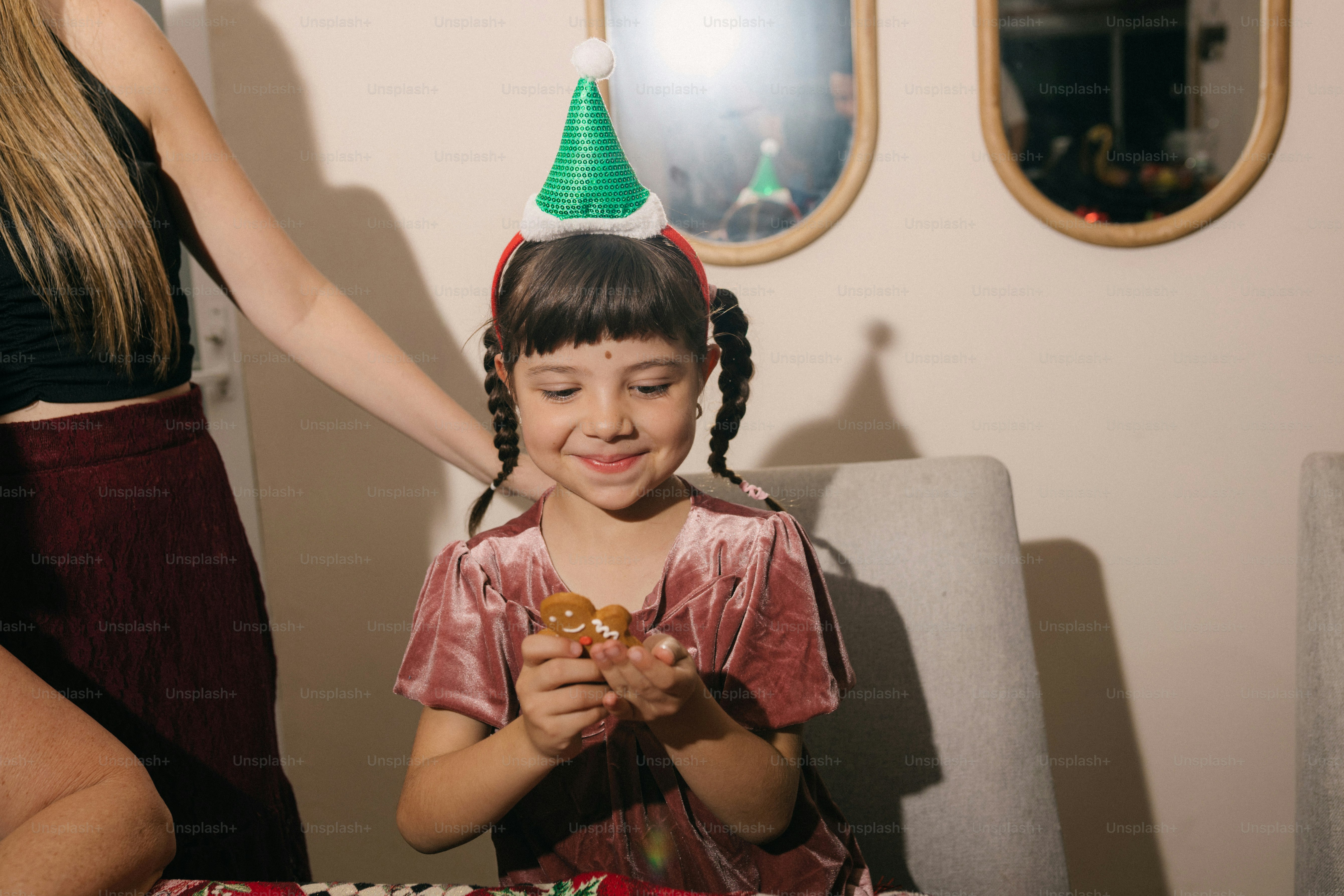 Junges Mädchen mit Partyhut hält ein Geschenk