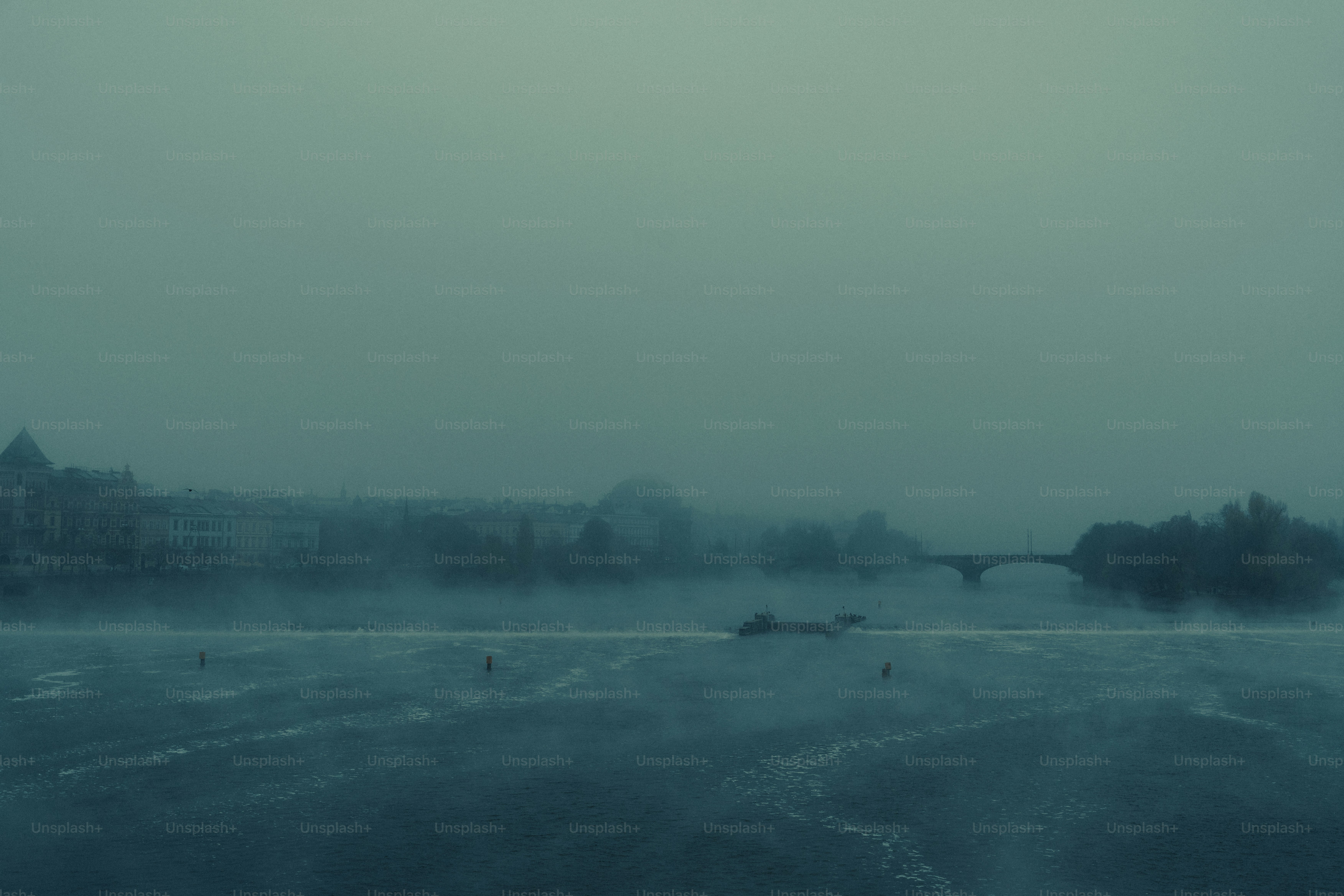 Misty river with distant buildings and bridge