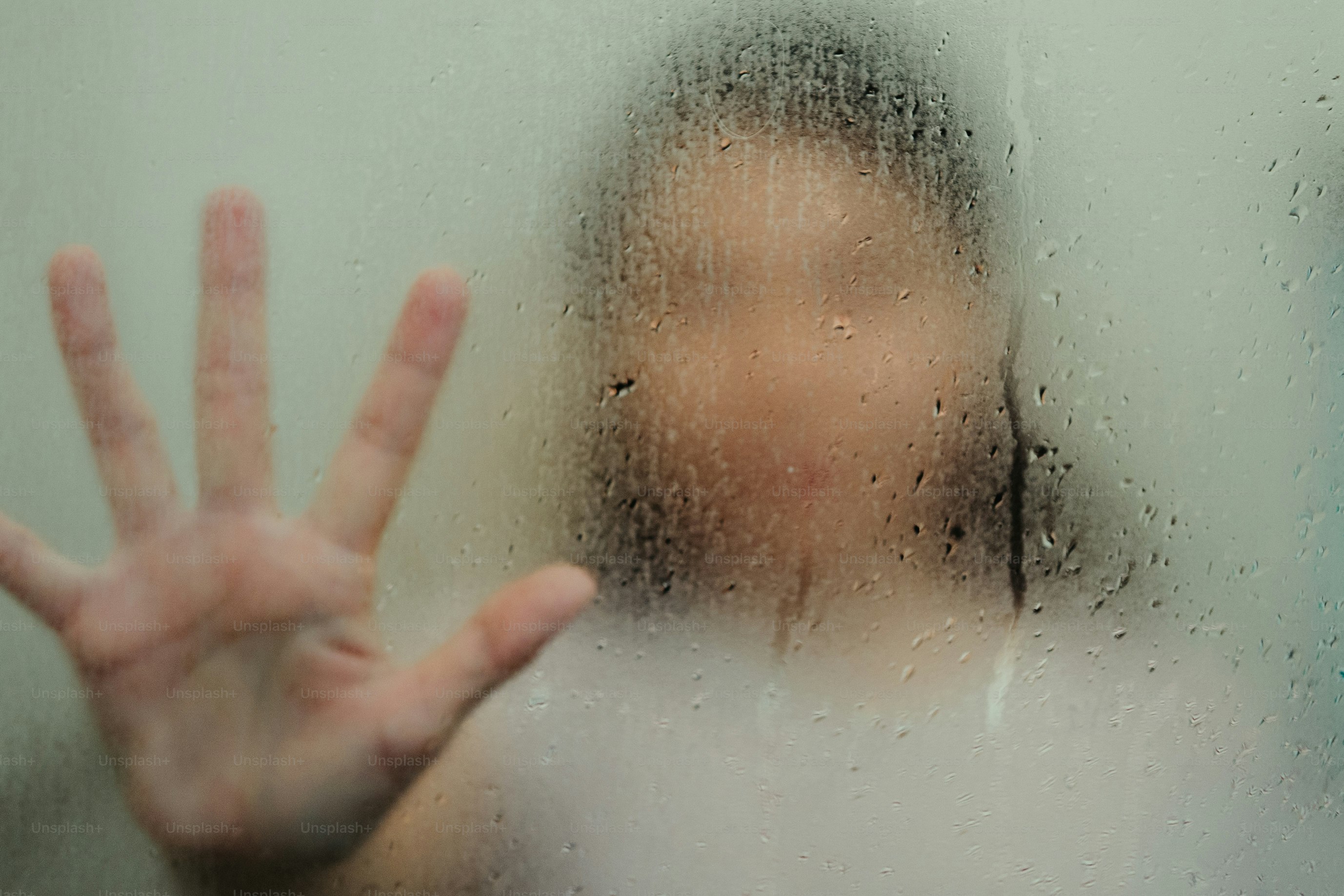 Die Hand der Person drückte gegen dampfendes Glas