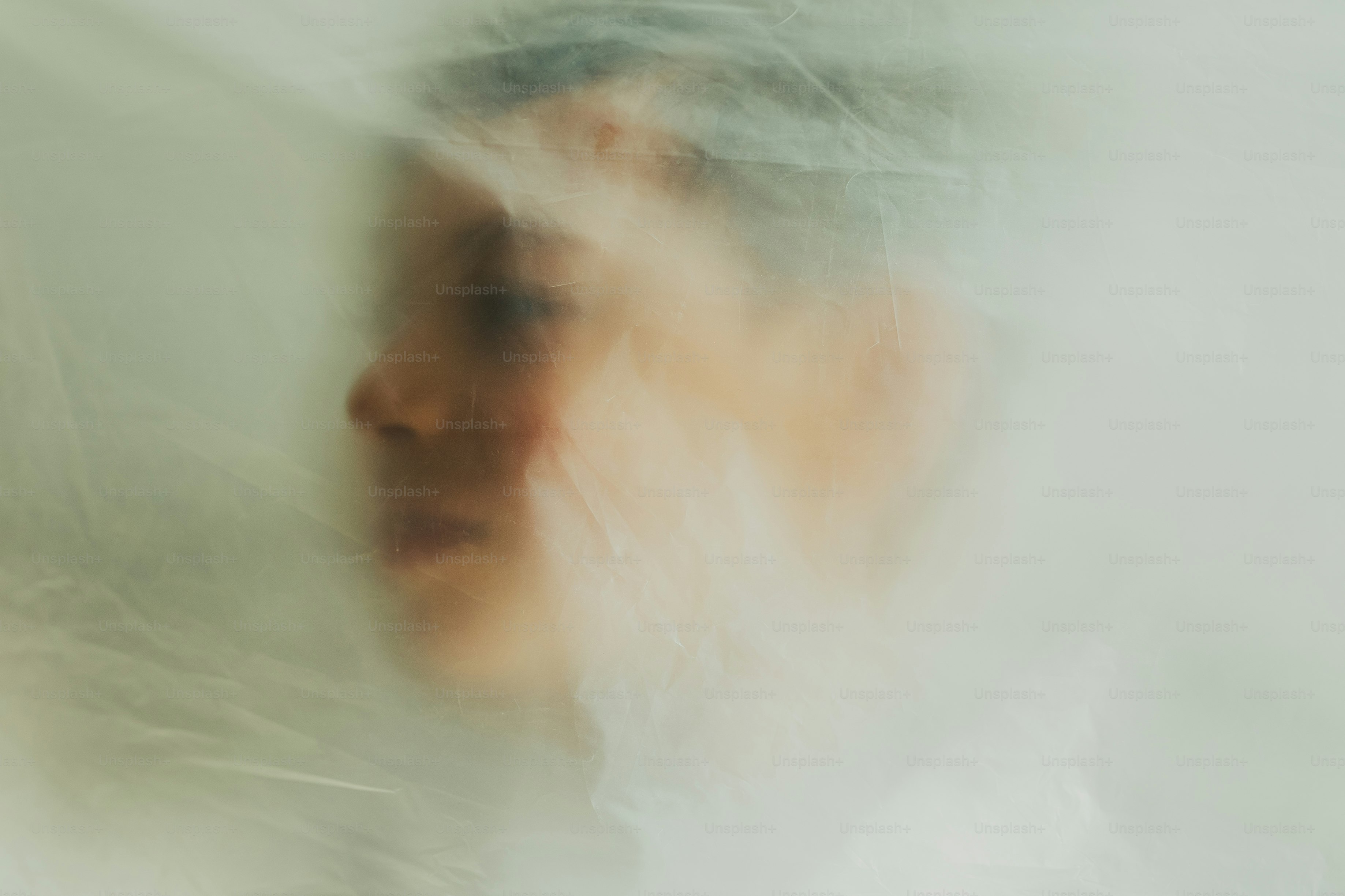 半透明の素材の向こうにぼやけた人物の横顔。