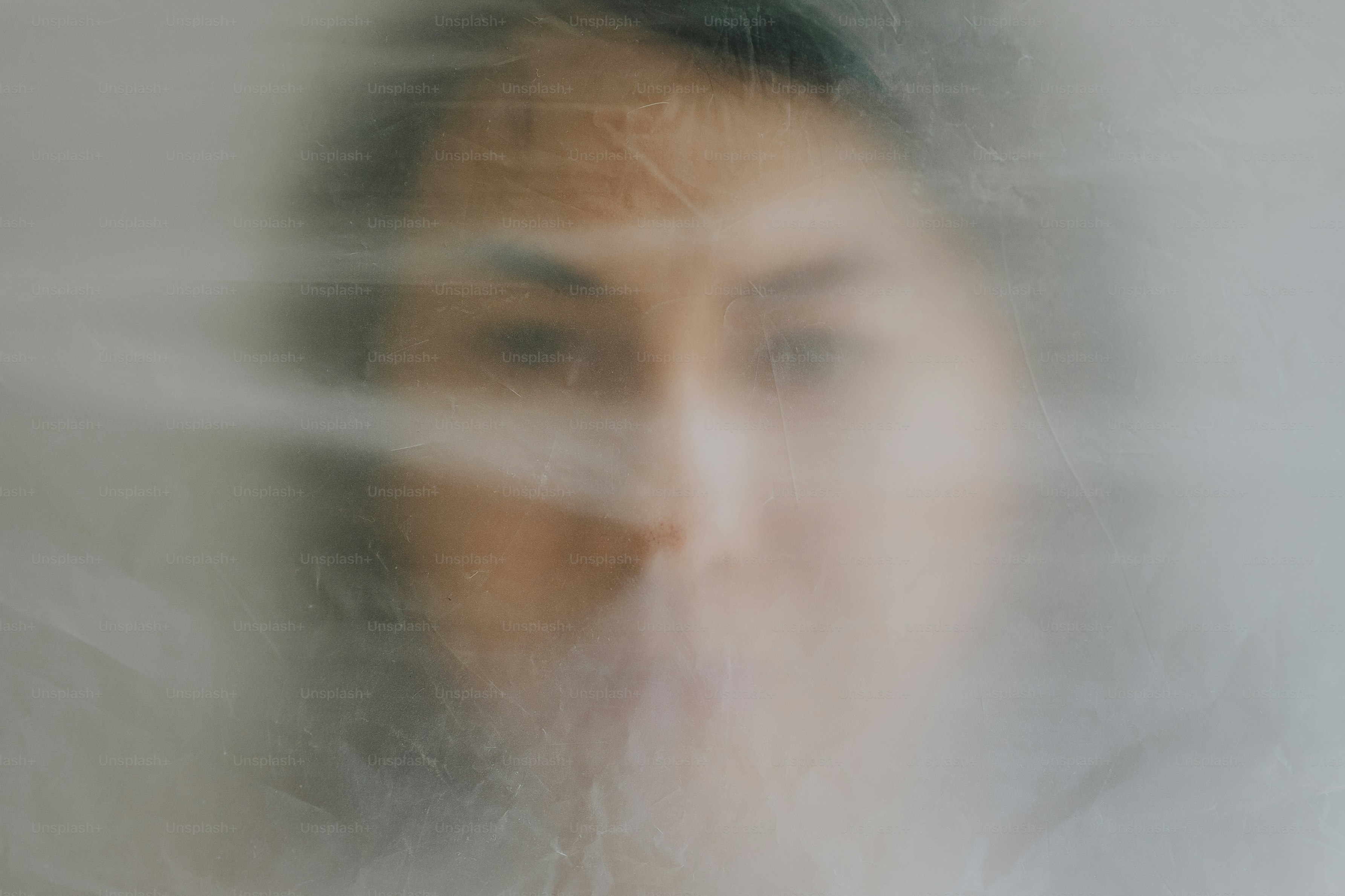 Das Gesicht einer Person ist von einem transparenten Stoff verdeckt