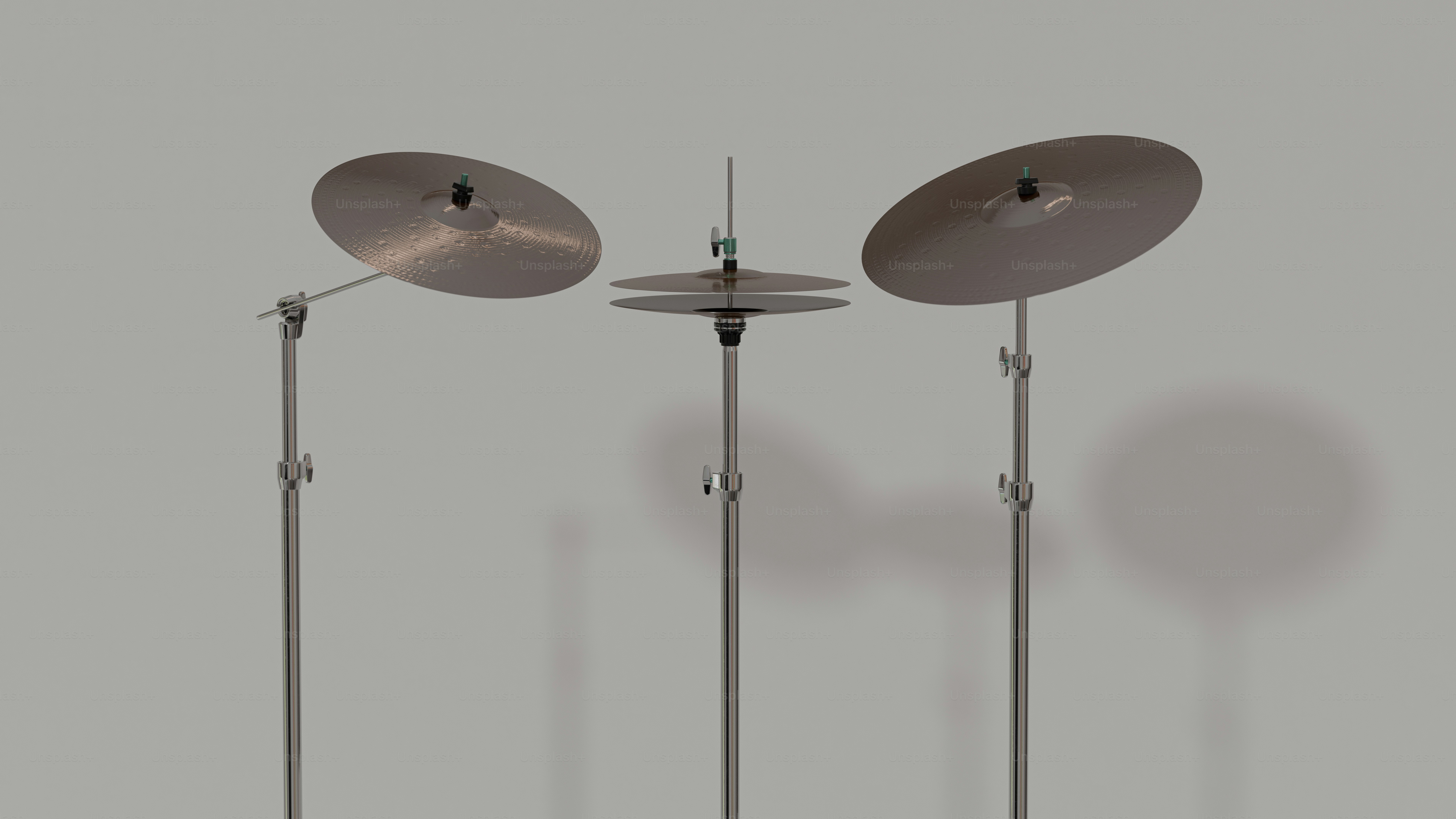 灰色の背景に立てられた三つのシンバル。