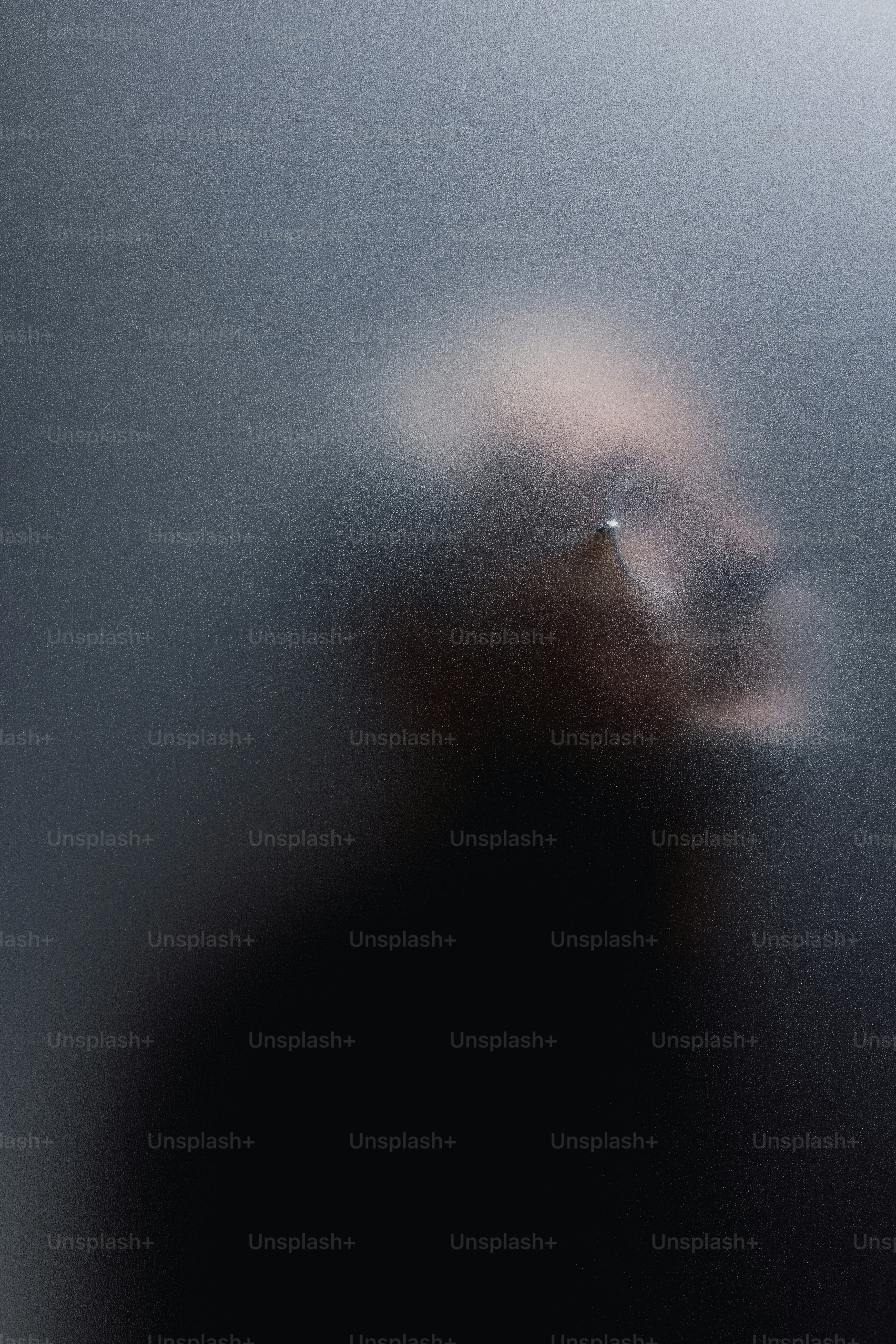 Blurred silhouette of a person wearing glasses