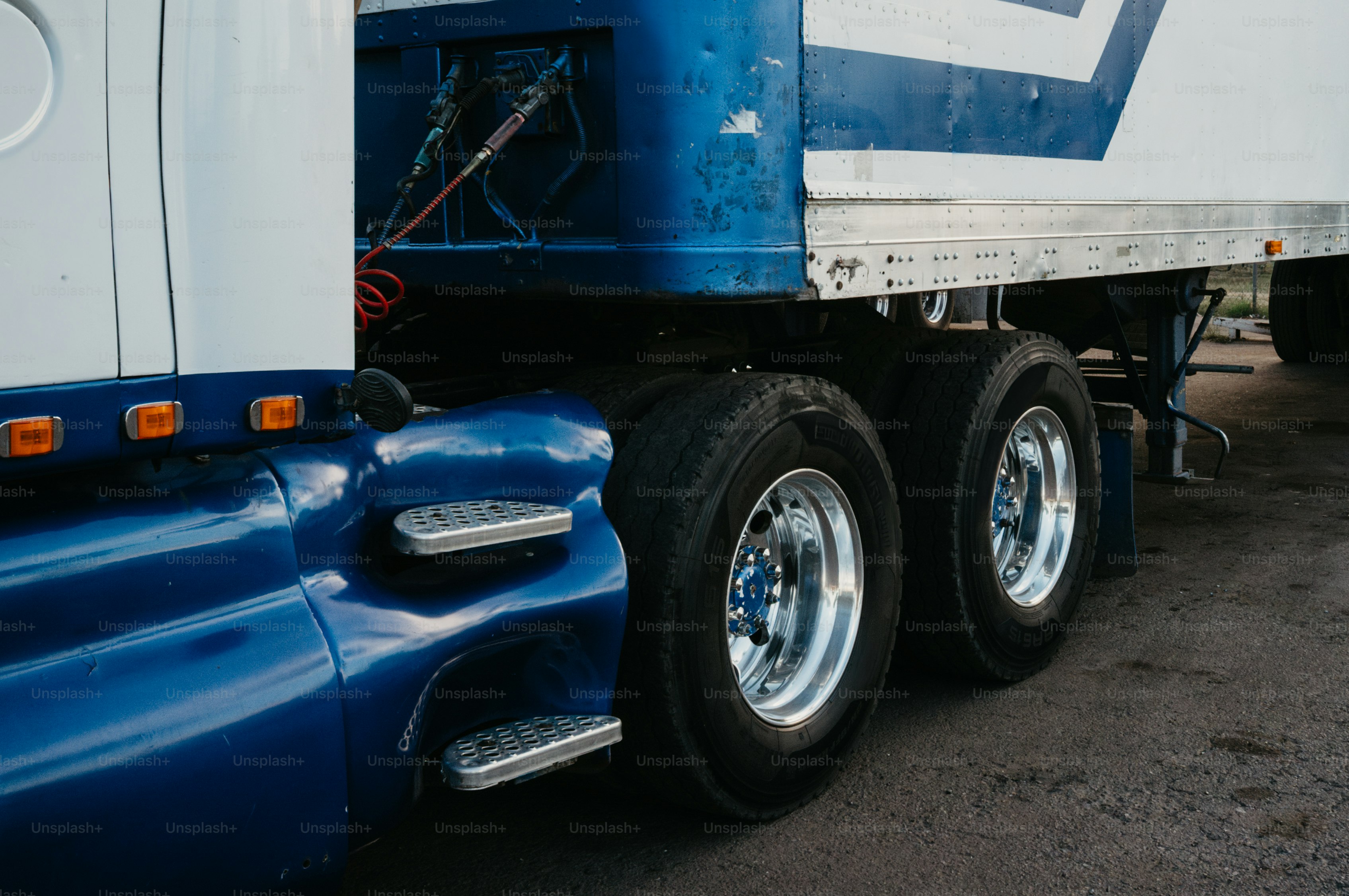 Close-up of a blue and white semi-truck's wheels