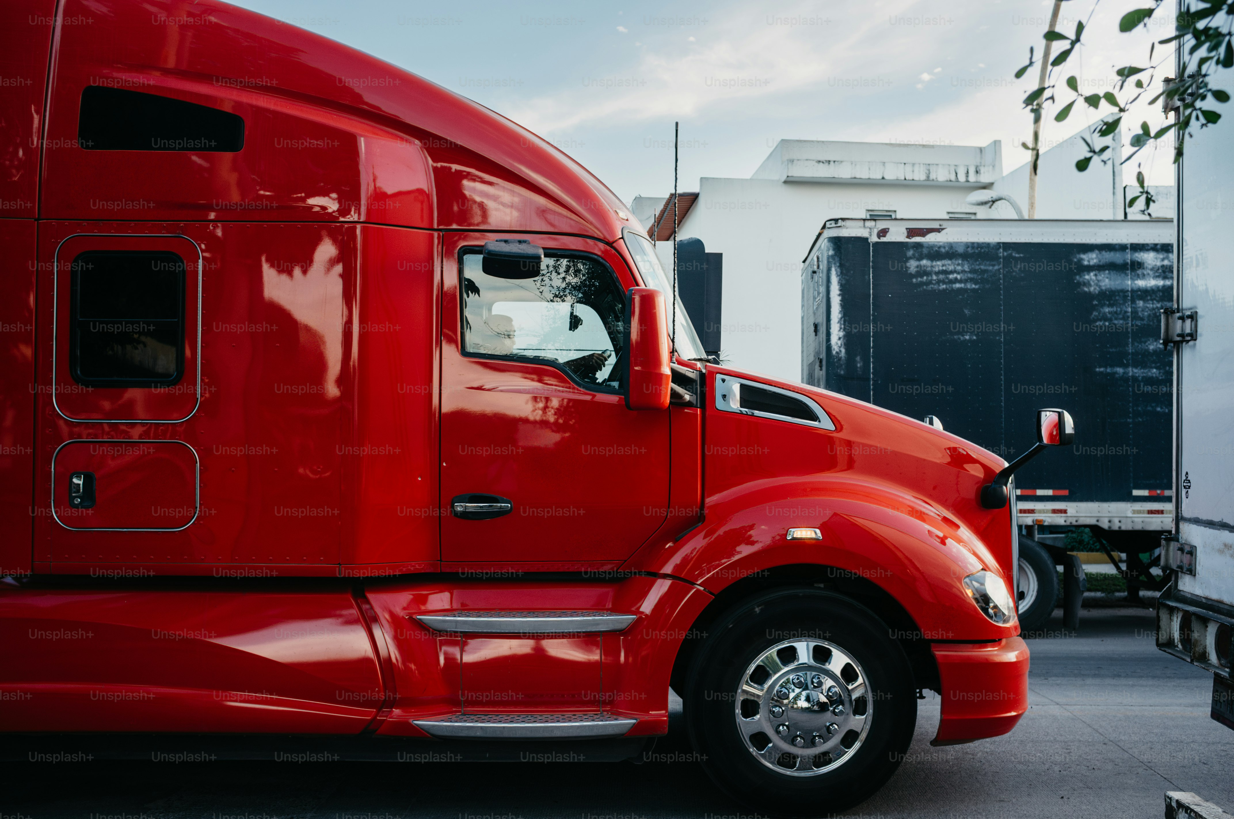A bright red semi-truck parked outdoors.