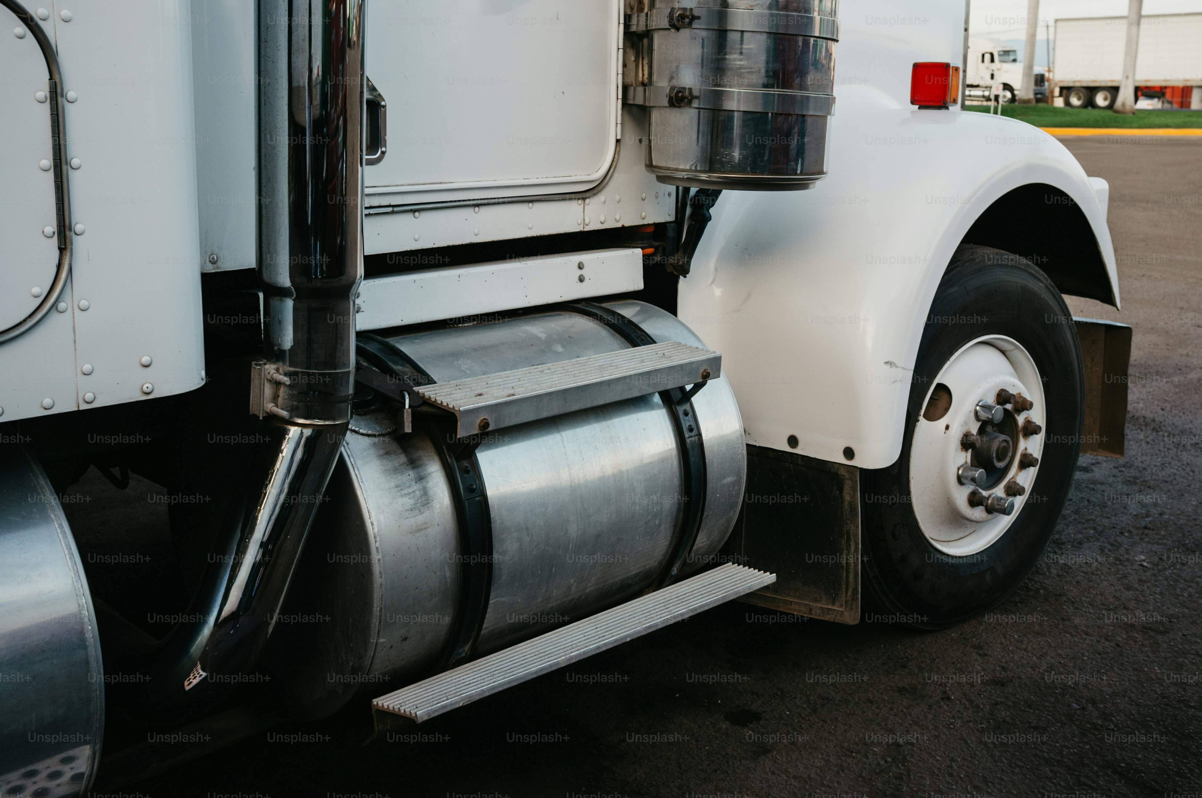 Close-up of a white semi-truck's fuel tank.