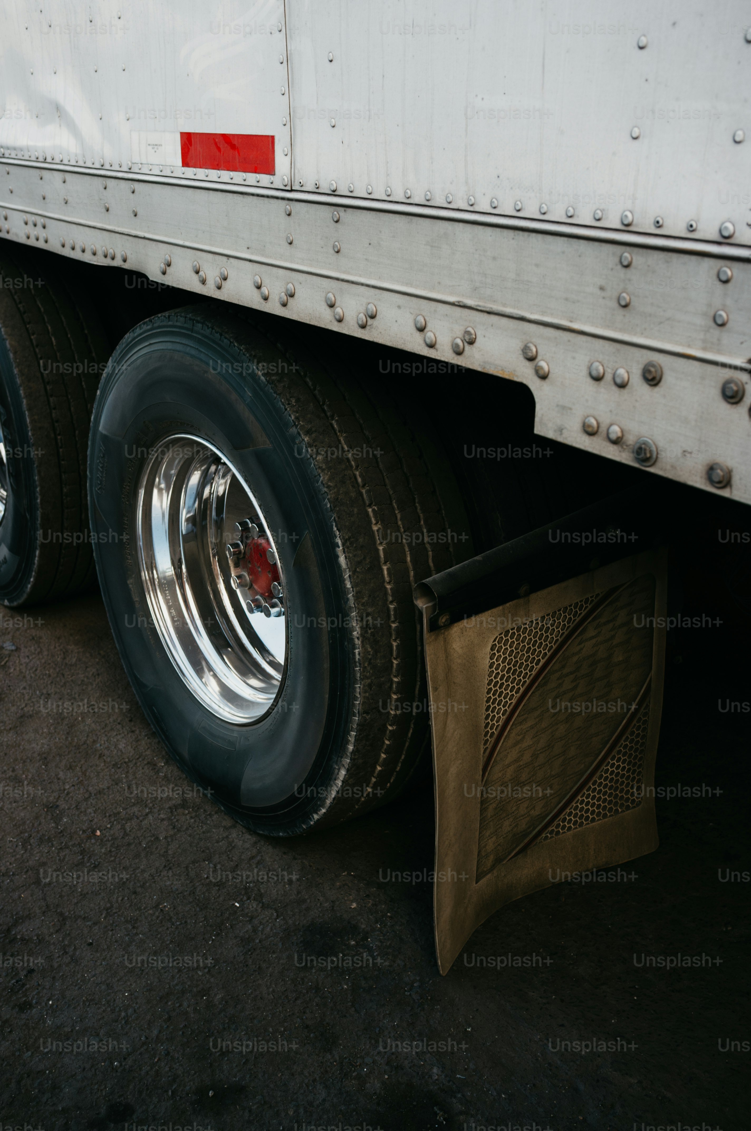 Close-up of a semi-truck's dual wheels and mud flap