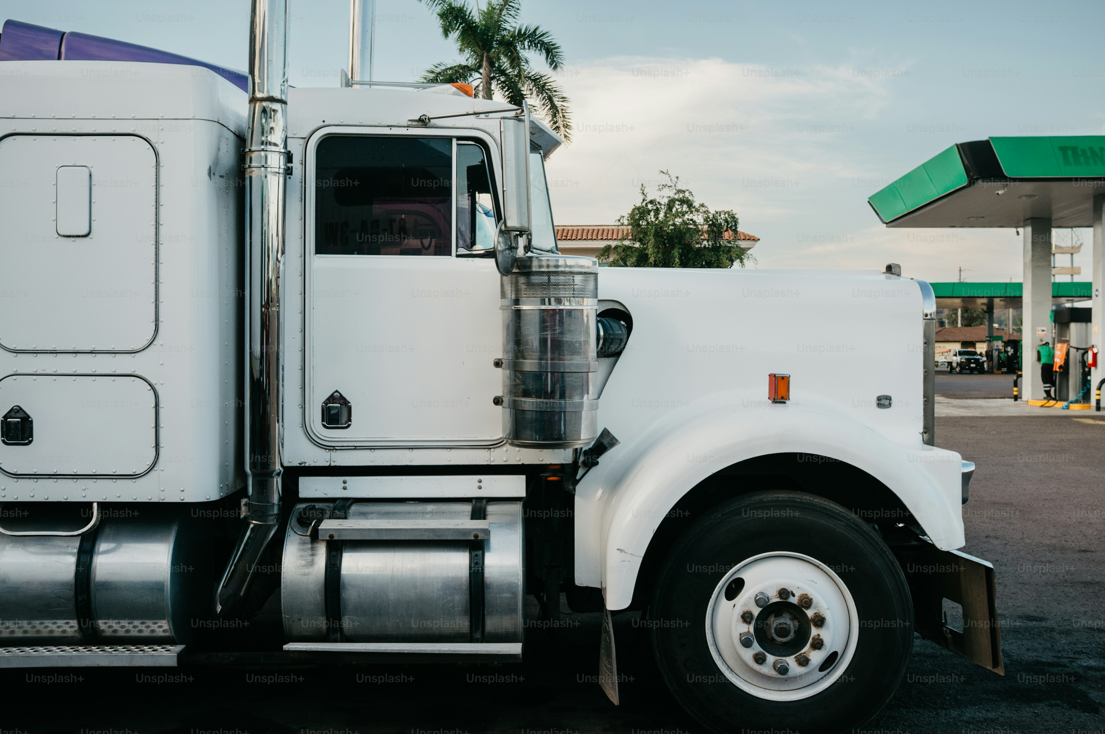 Truk semi putih diparkir di pompa bensin.