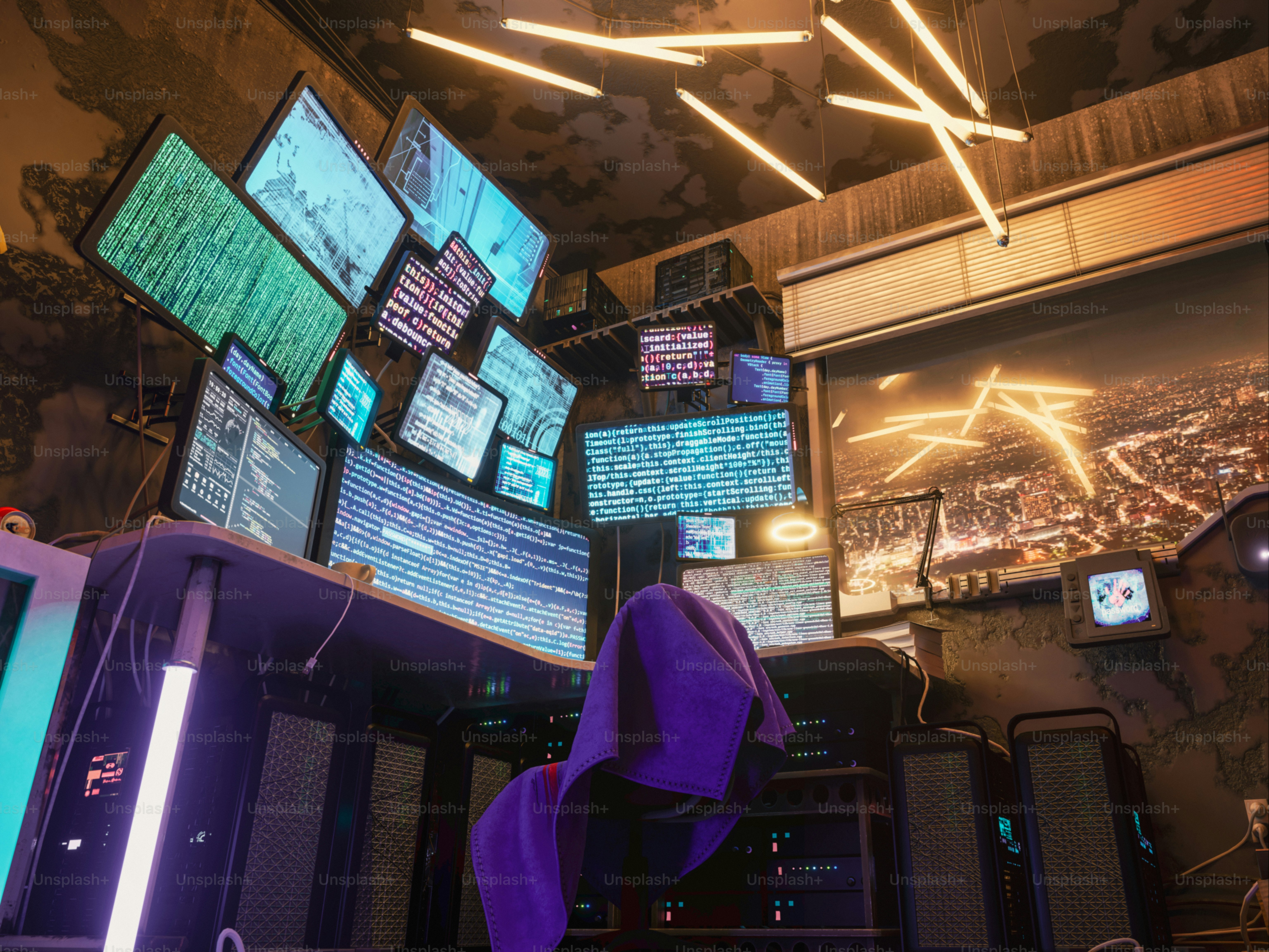 Multiple screens display data in a dimly lit room.
