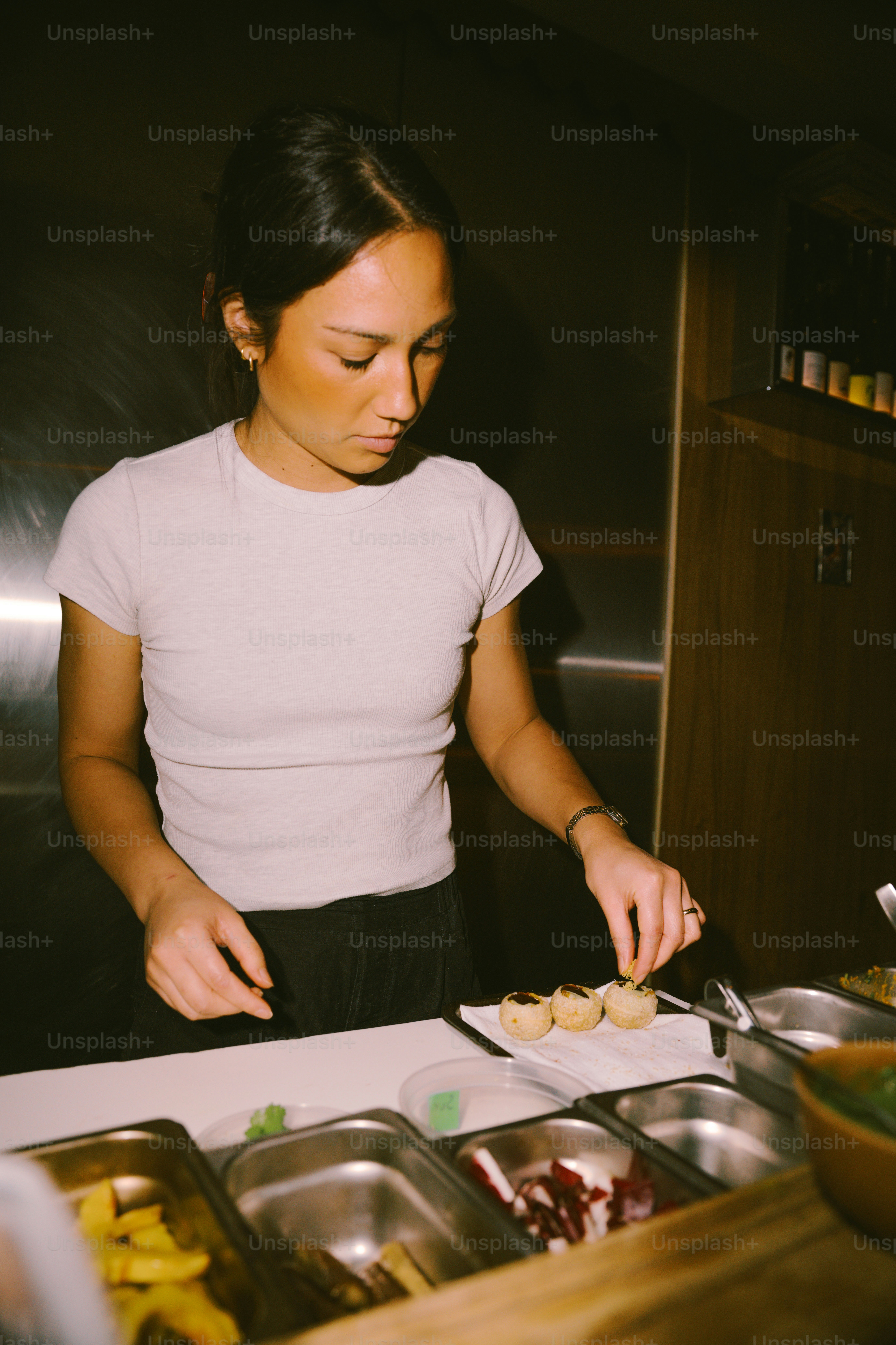 A woman prepares food behind a counter. photo – Restaurant Image on ...