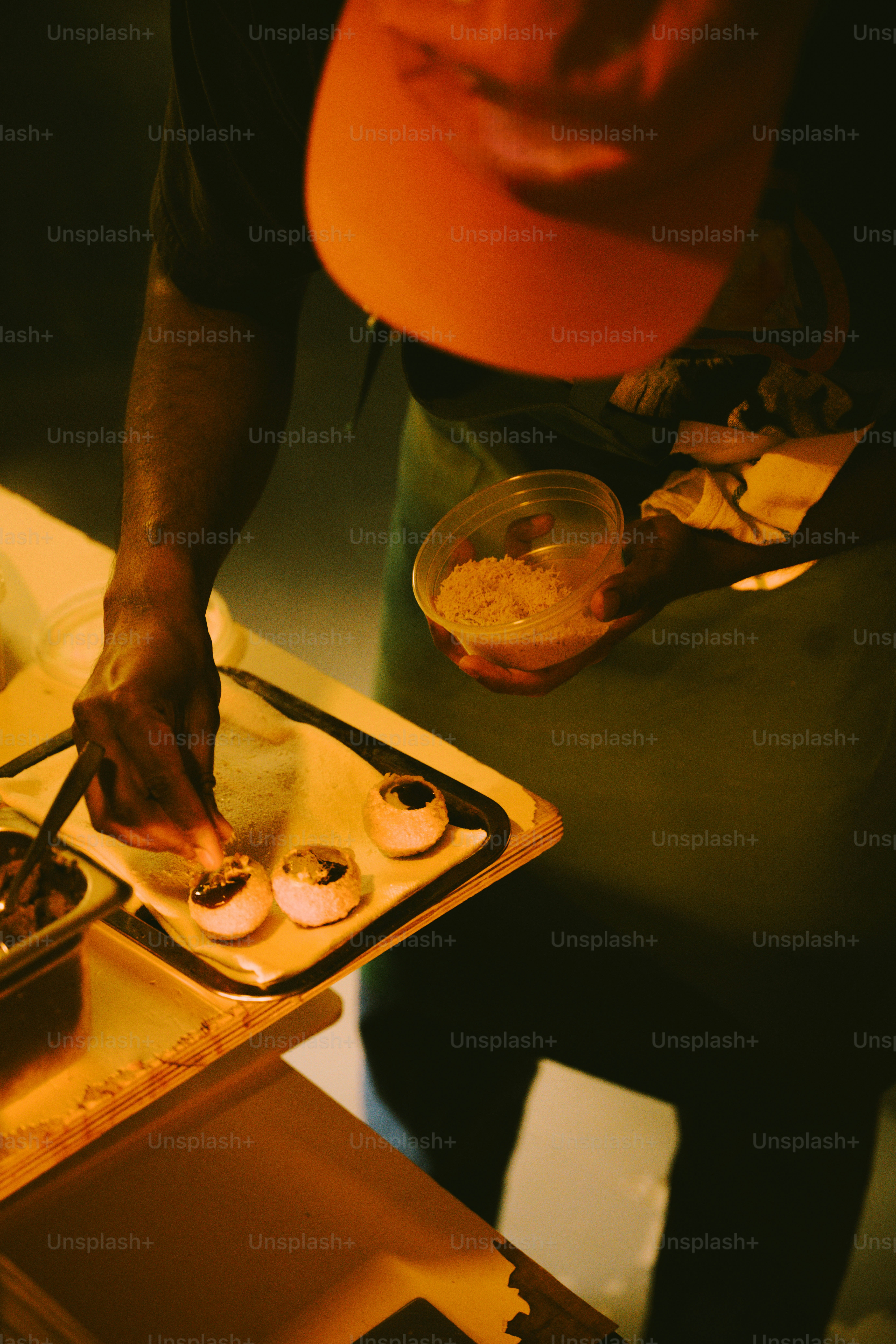 Chef decorating small pastries with toppings