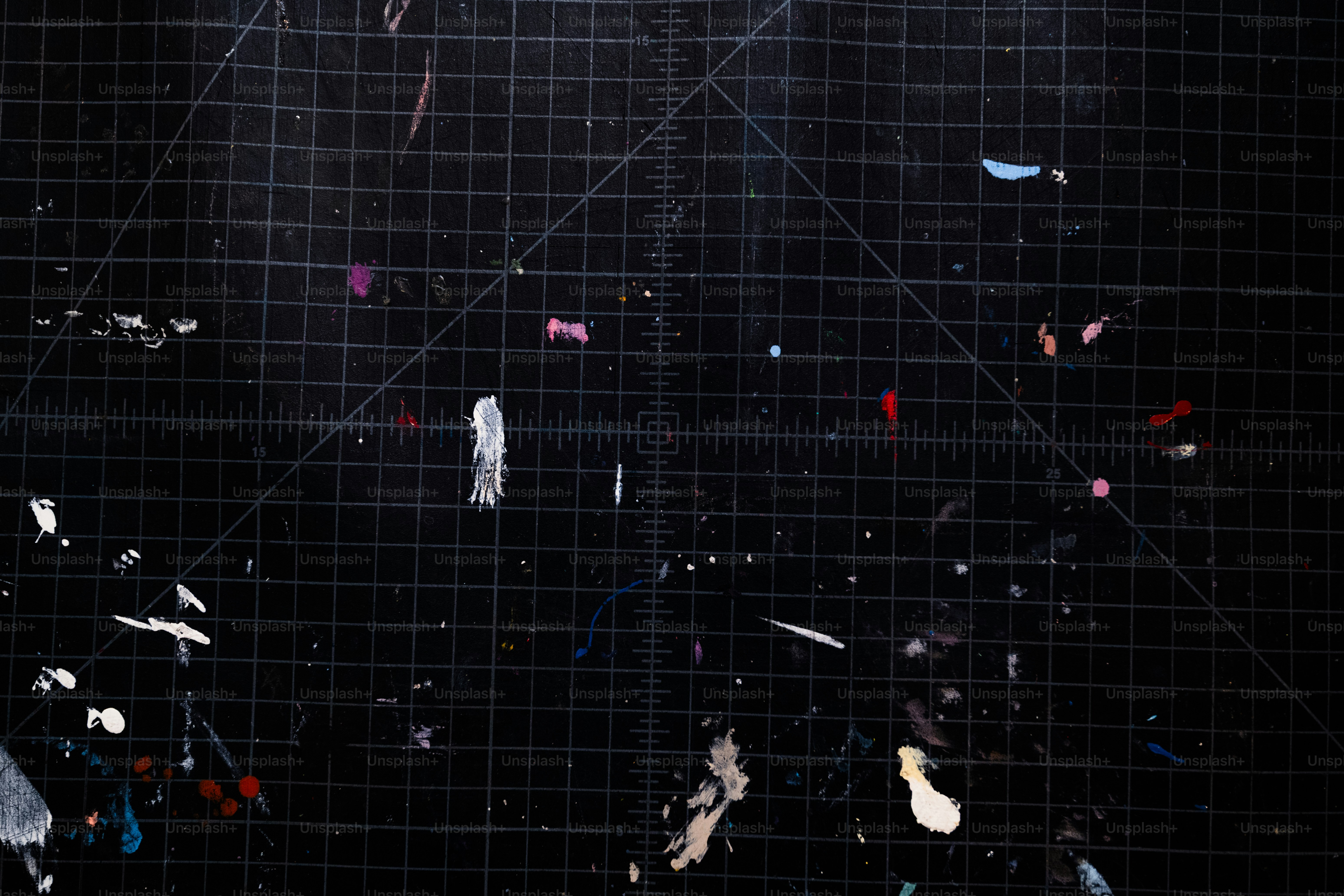 Scrap materials scattered on a black cutting mat.