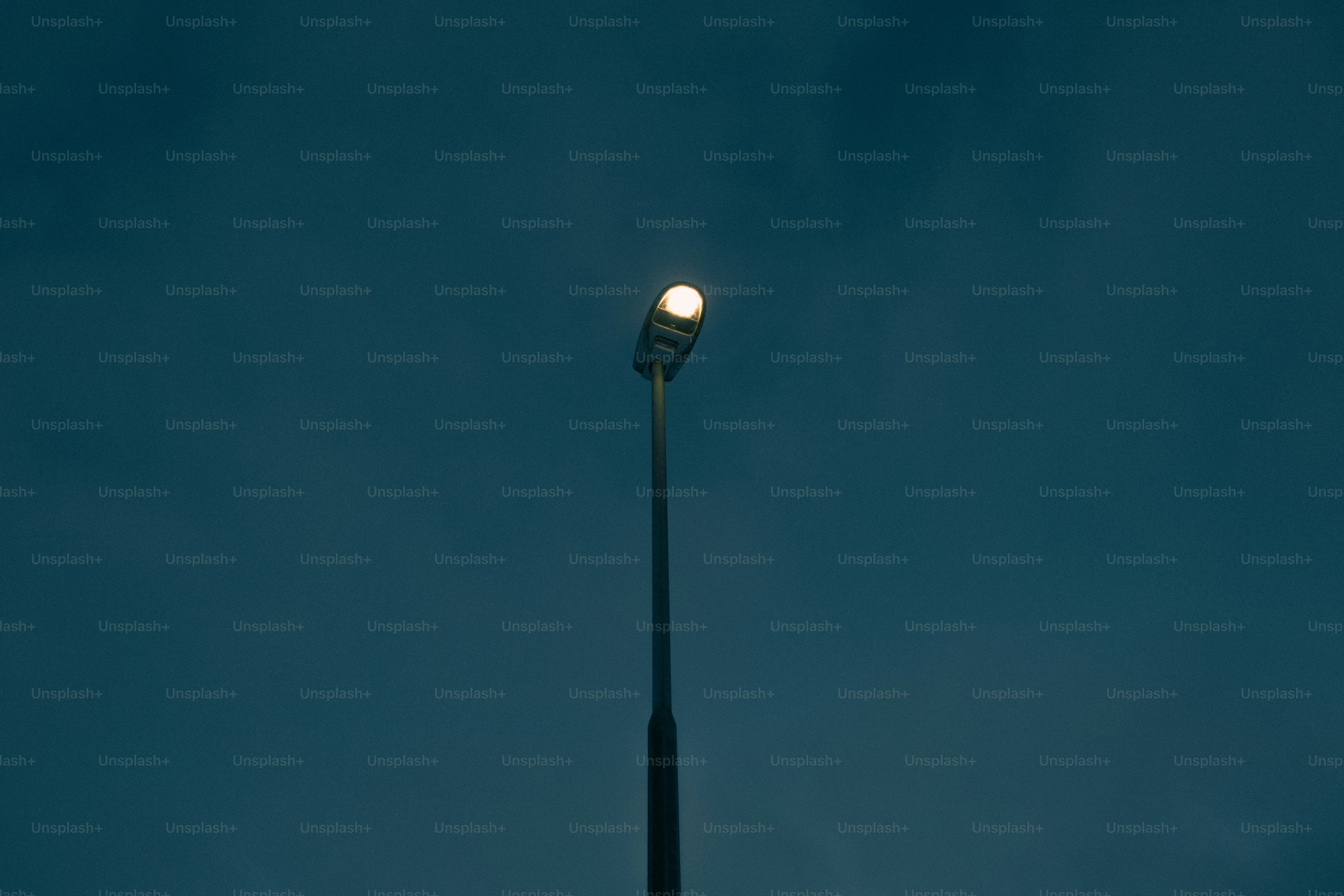 A lone street lamp glows against a dark sky