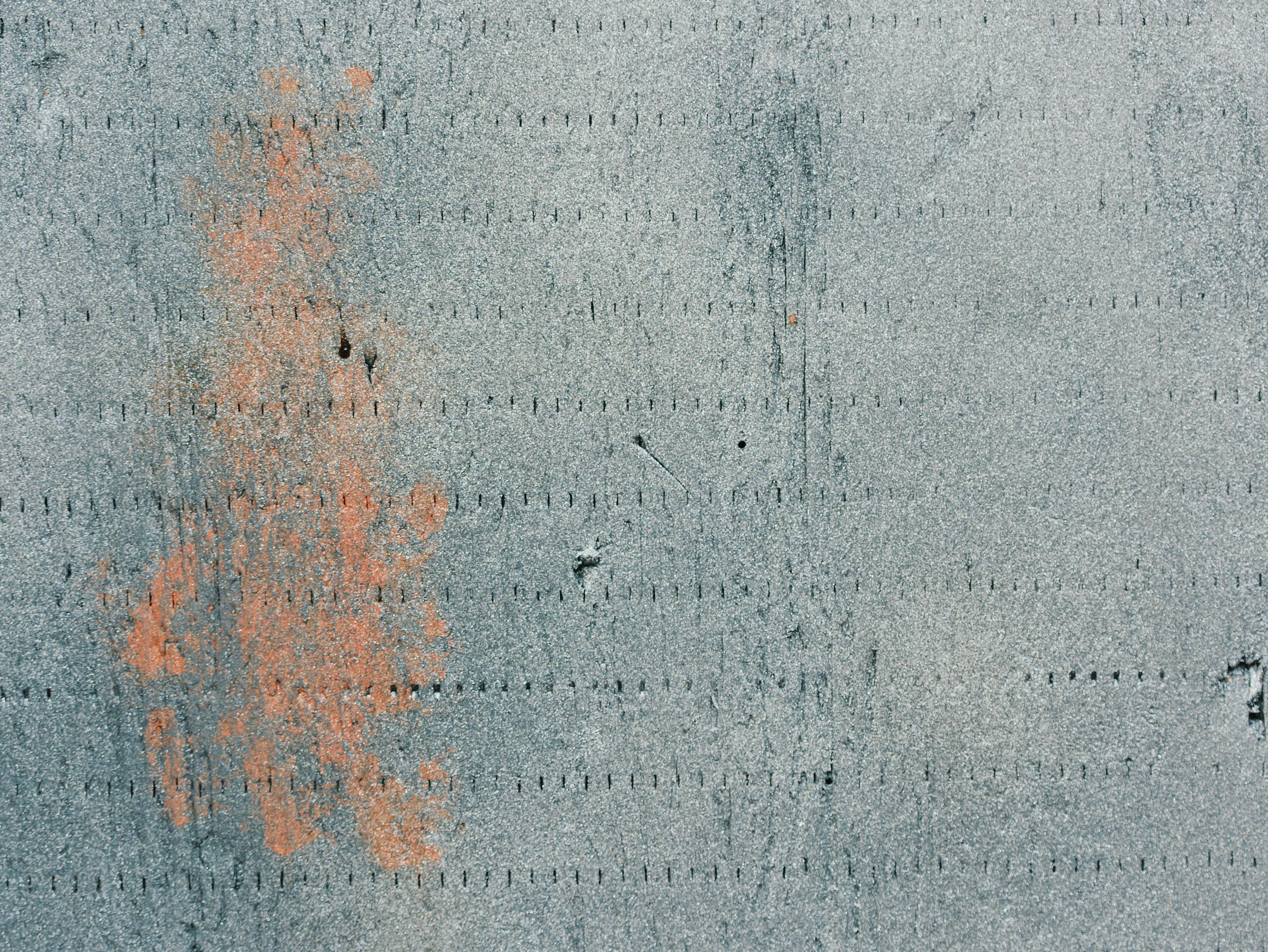 Rough textured gray surface with orange abstract mark