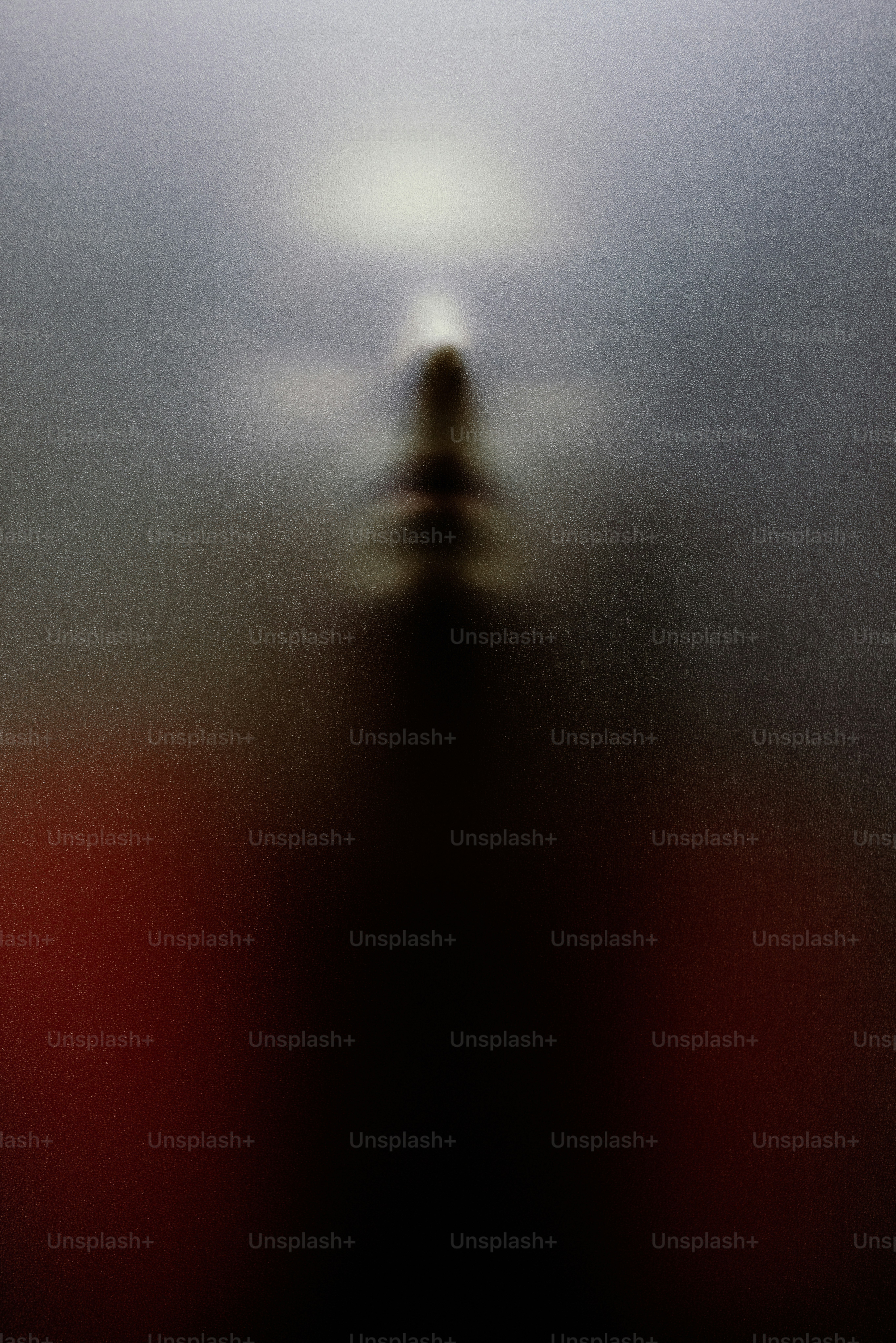 Blurred silhouette of a person behind frosted glass