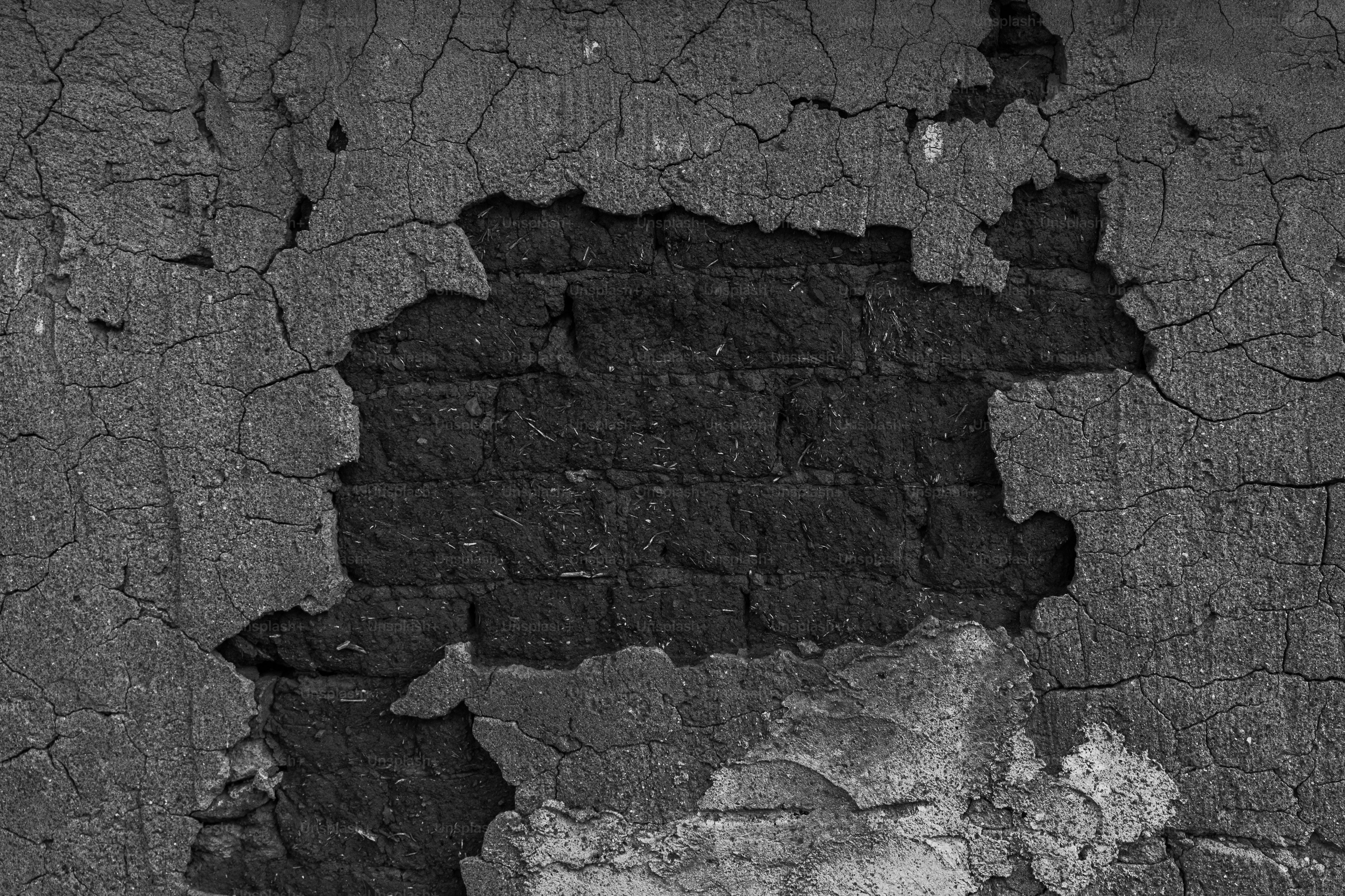 L'intonaco crepato rivela una texture scura da muro di mattoni