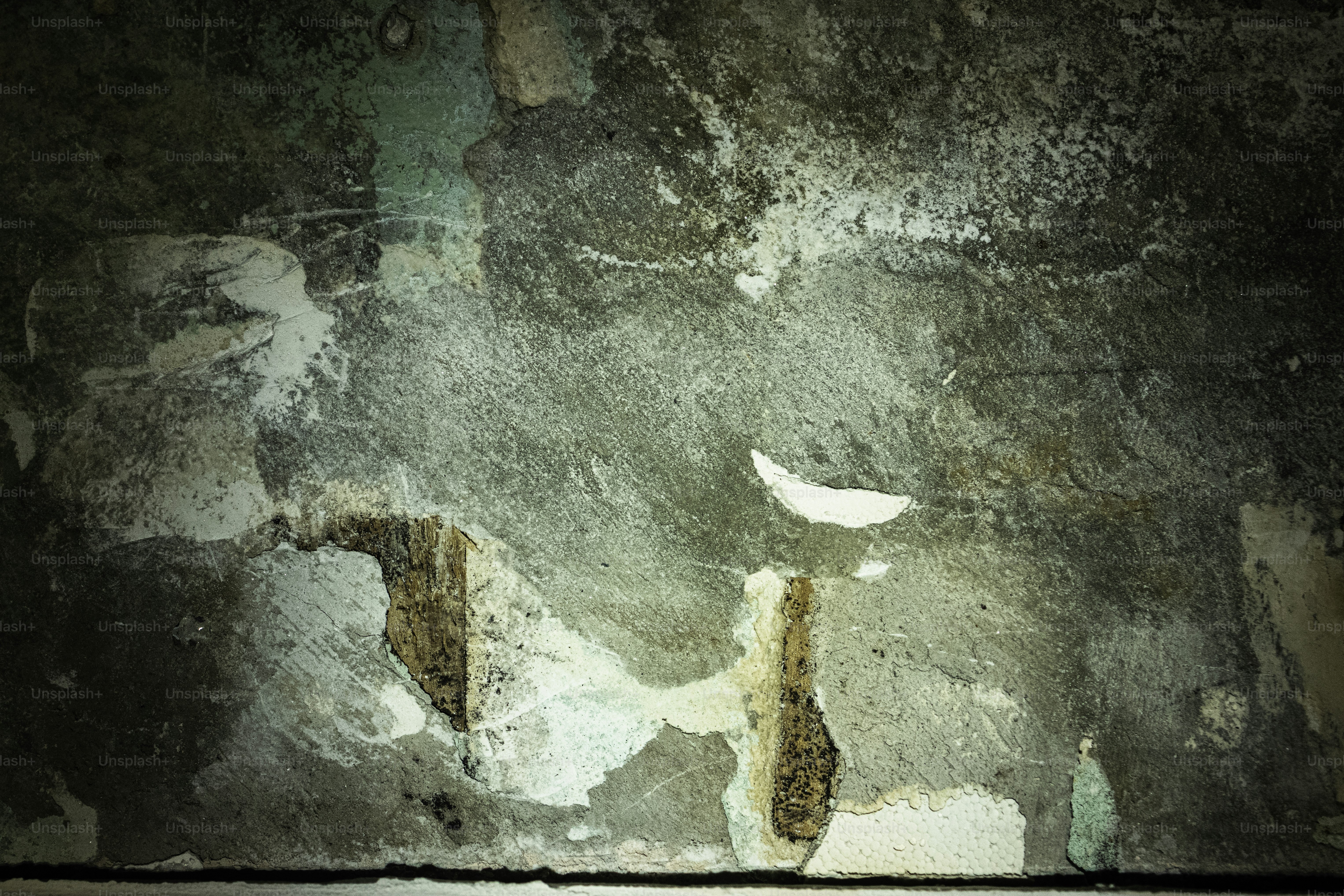 Un muro di cemento testurizzato, in abbattuta, con vernice scrostata.