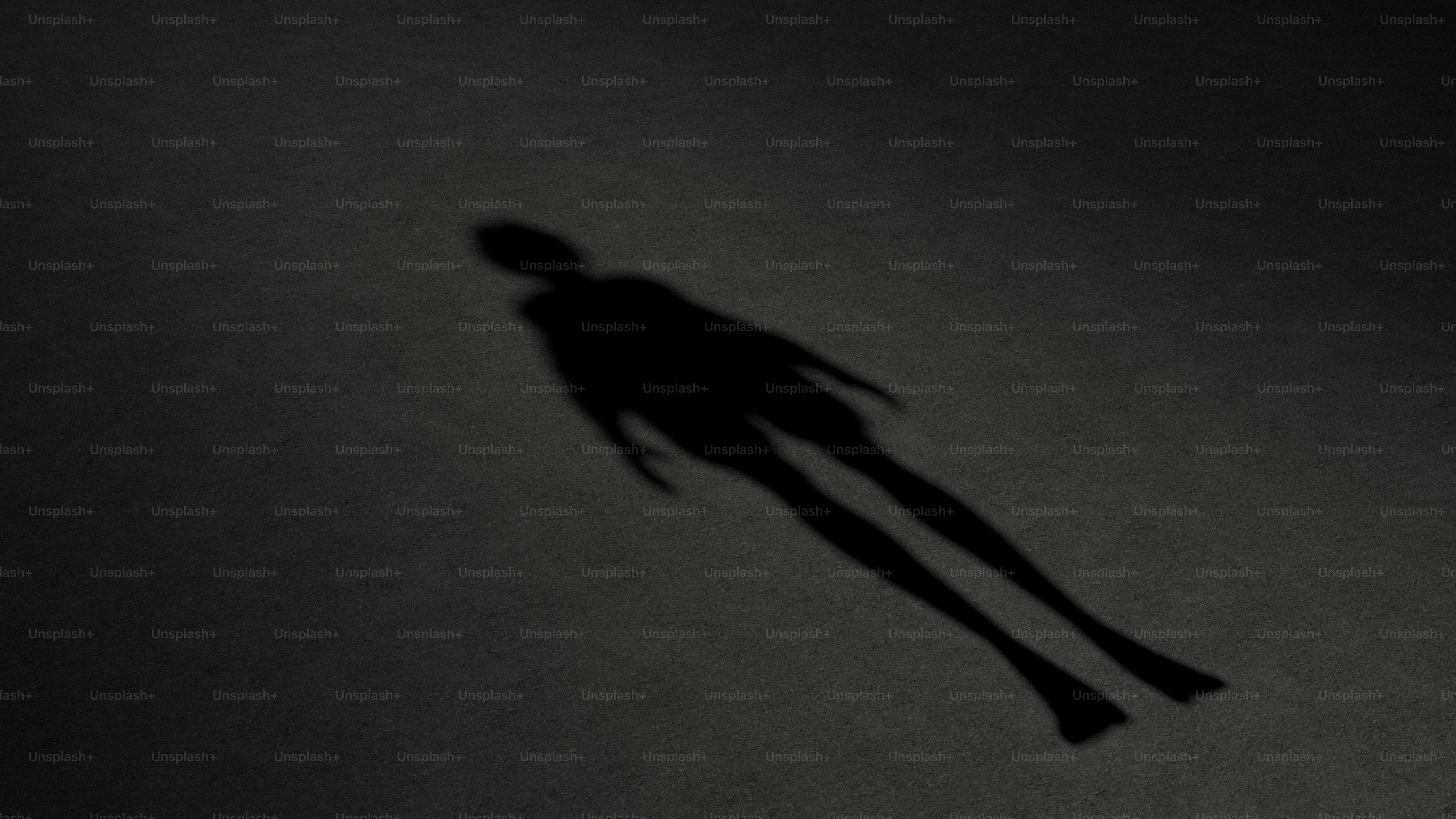 暗い表面に横たわる人の影