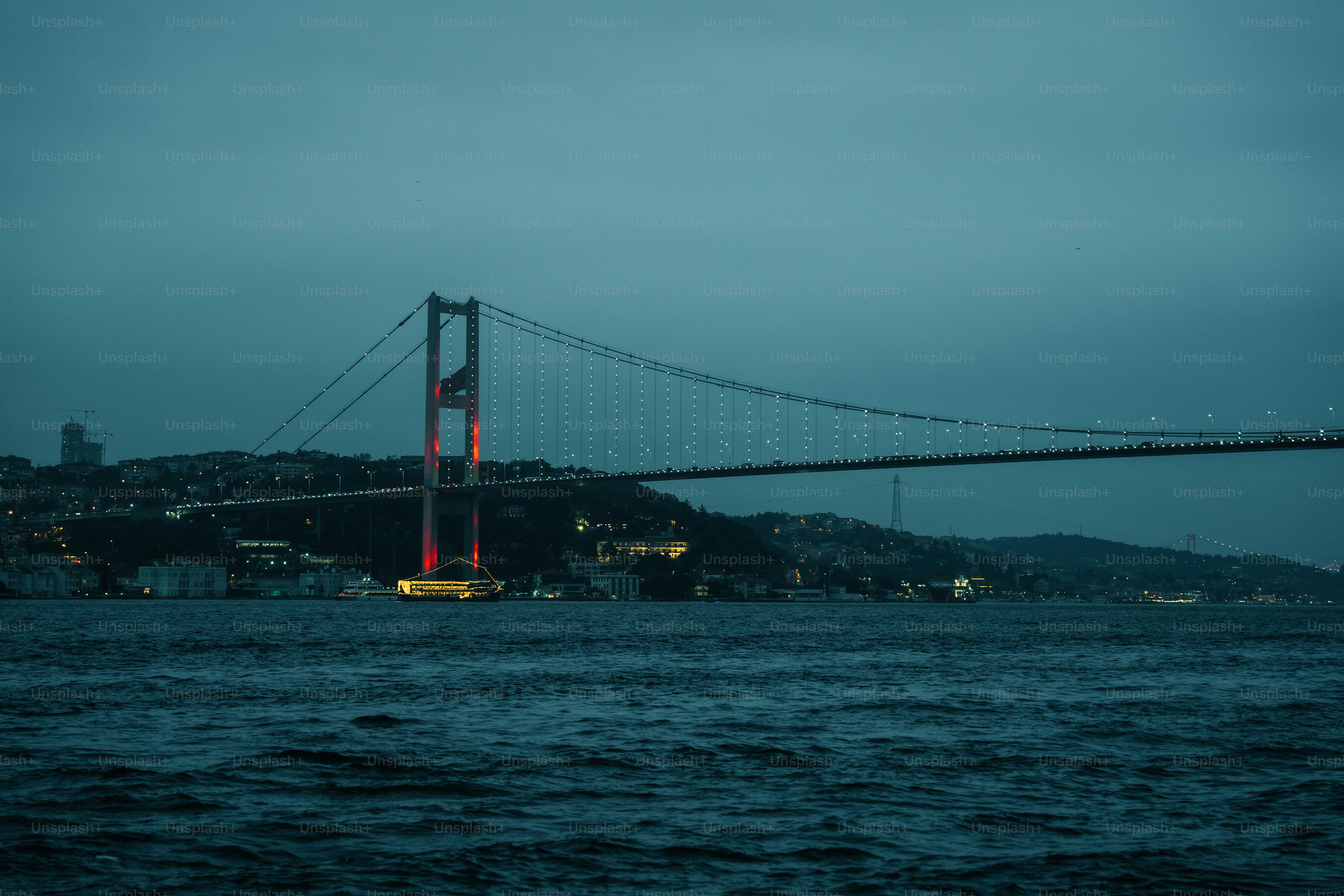 Suspension bridge over dark water at dusk