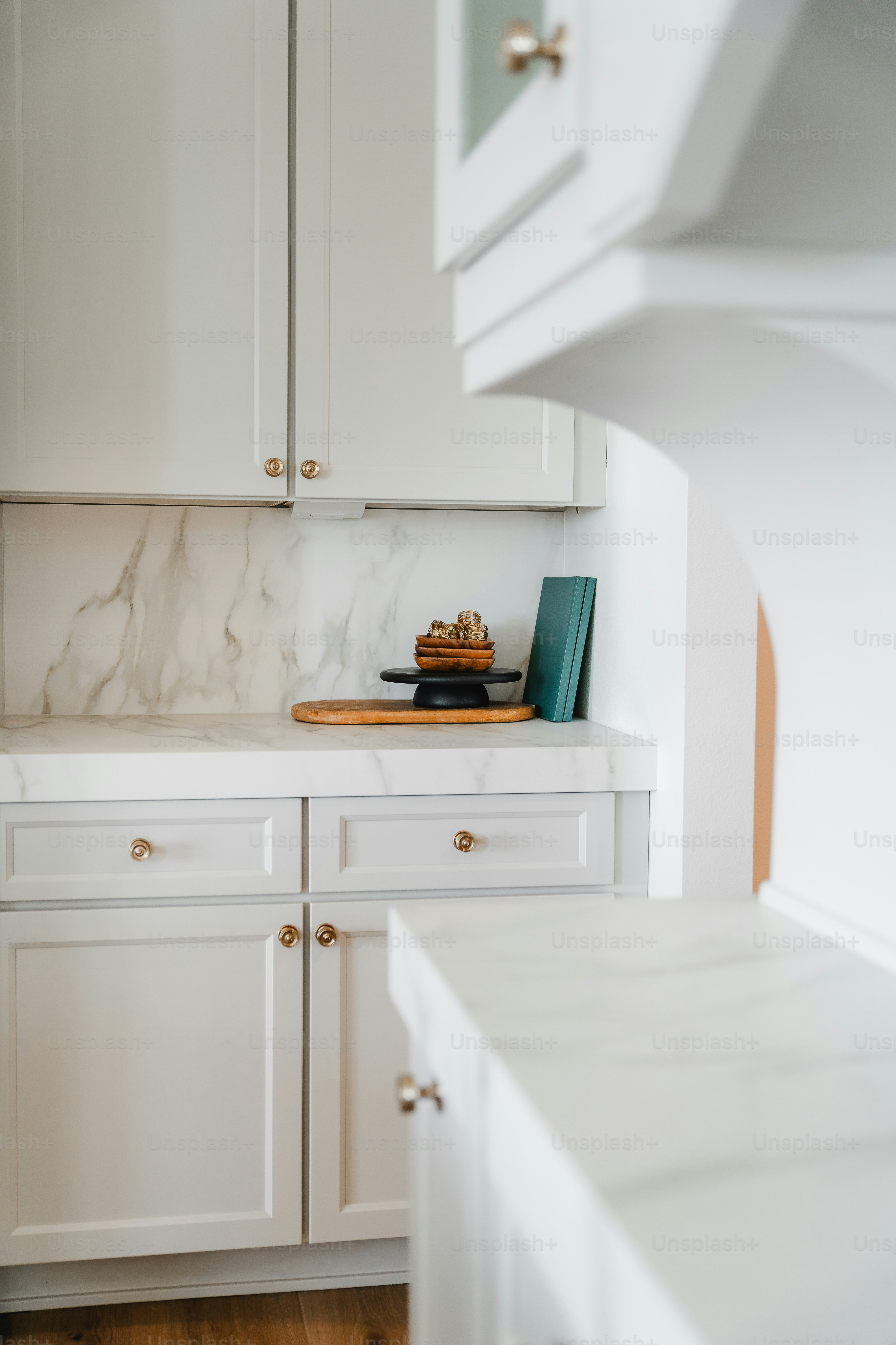 Modern white kitchen with marble countertops and backsplash