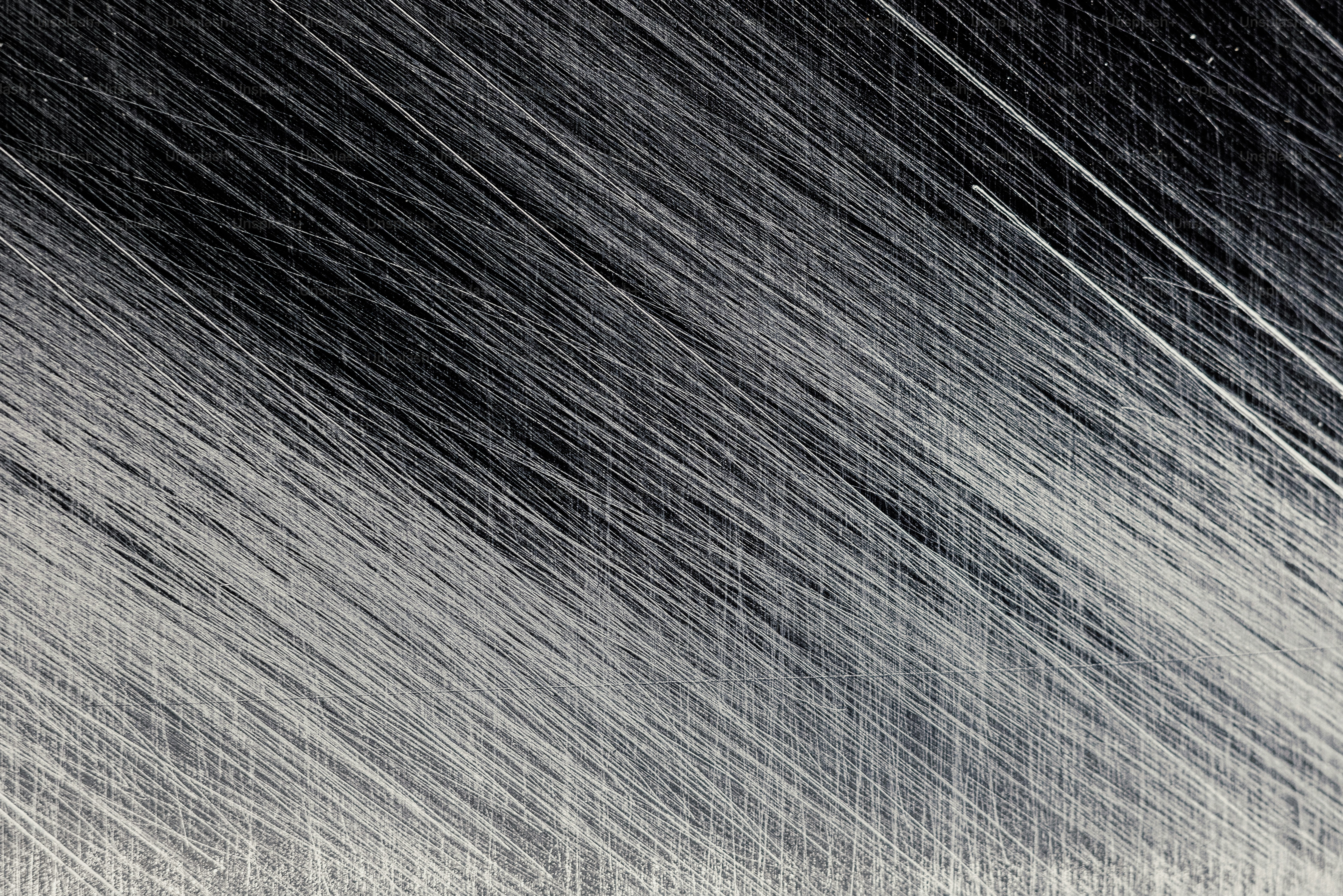 斜めにブラッシングされた金属テクスチャーの抽象的なパターン。