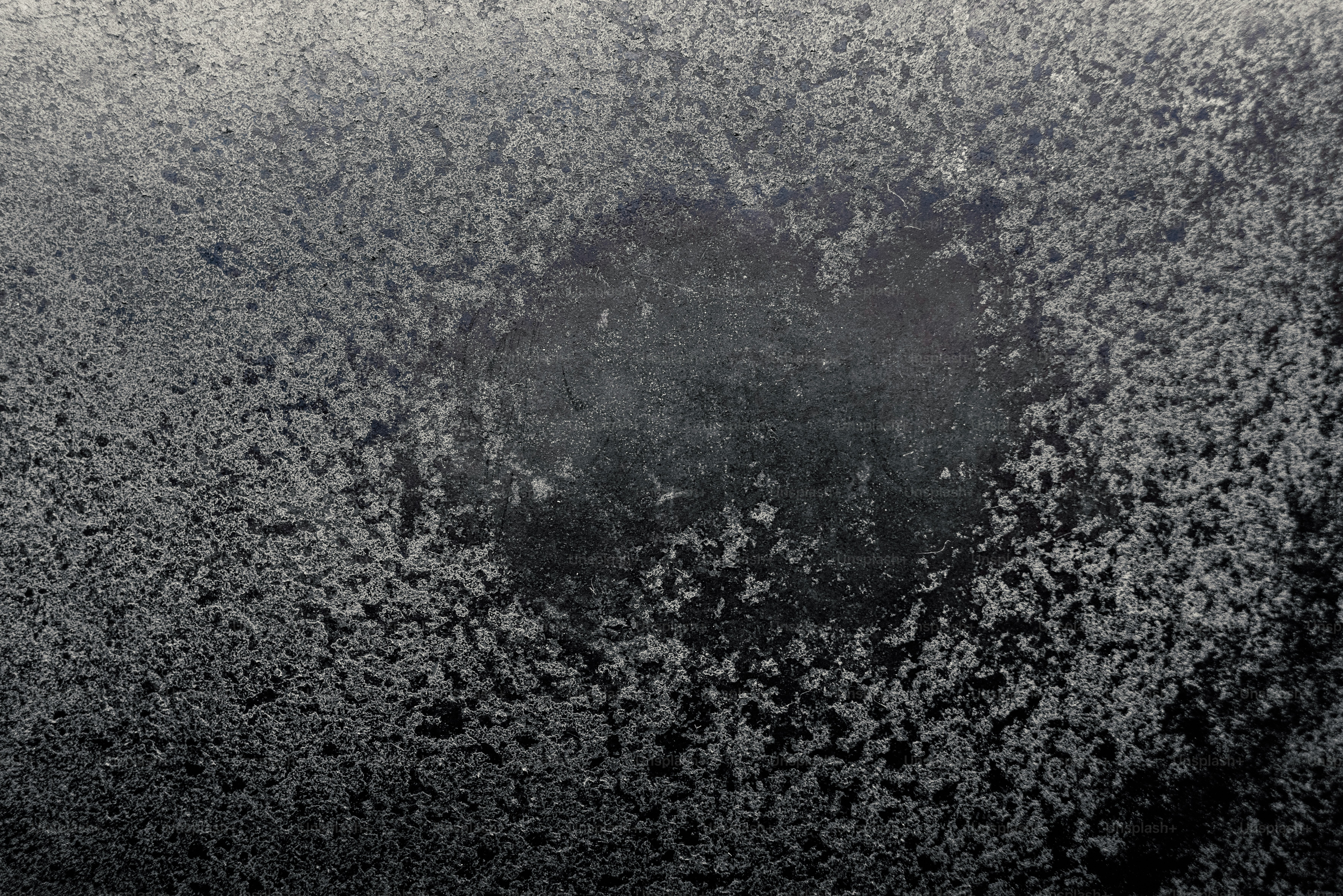 暗い表面に形成される氷の結晶のクローズアップ