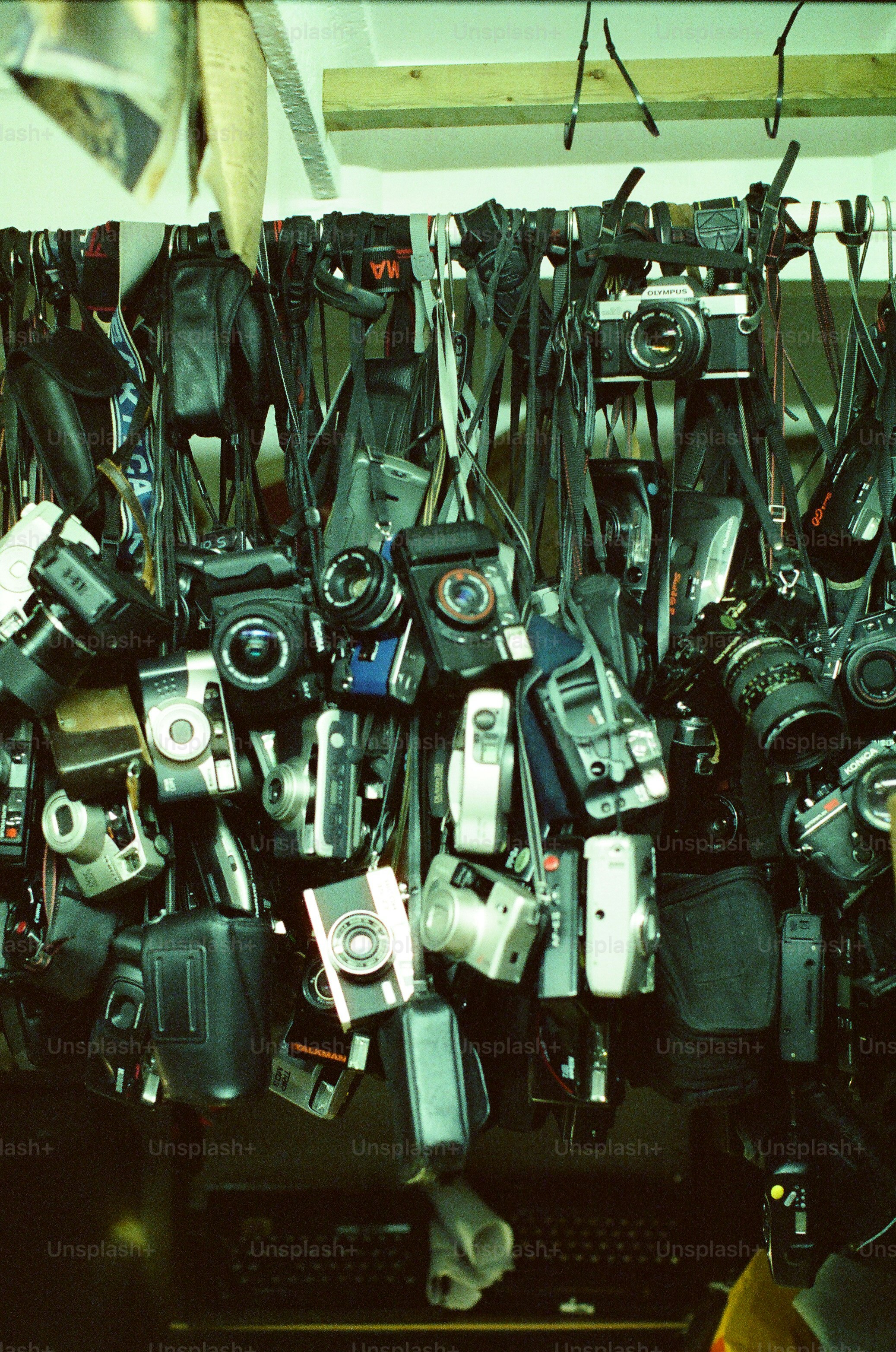 Collection of vintage cameras hanging on a rack.