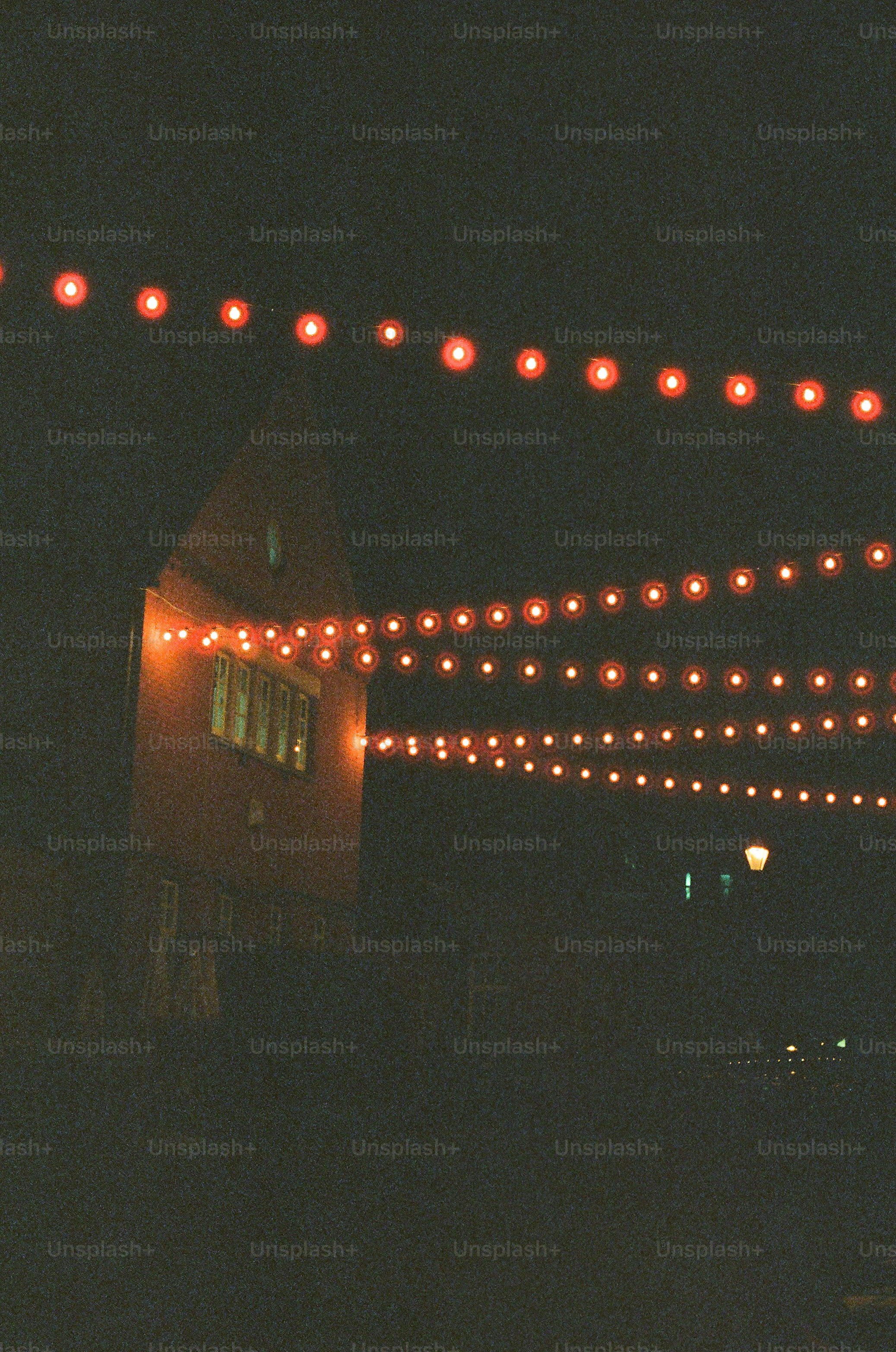 Red string lights illuminate a building at night