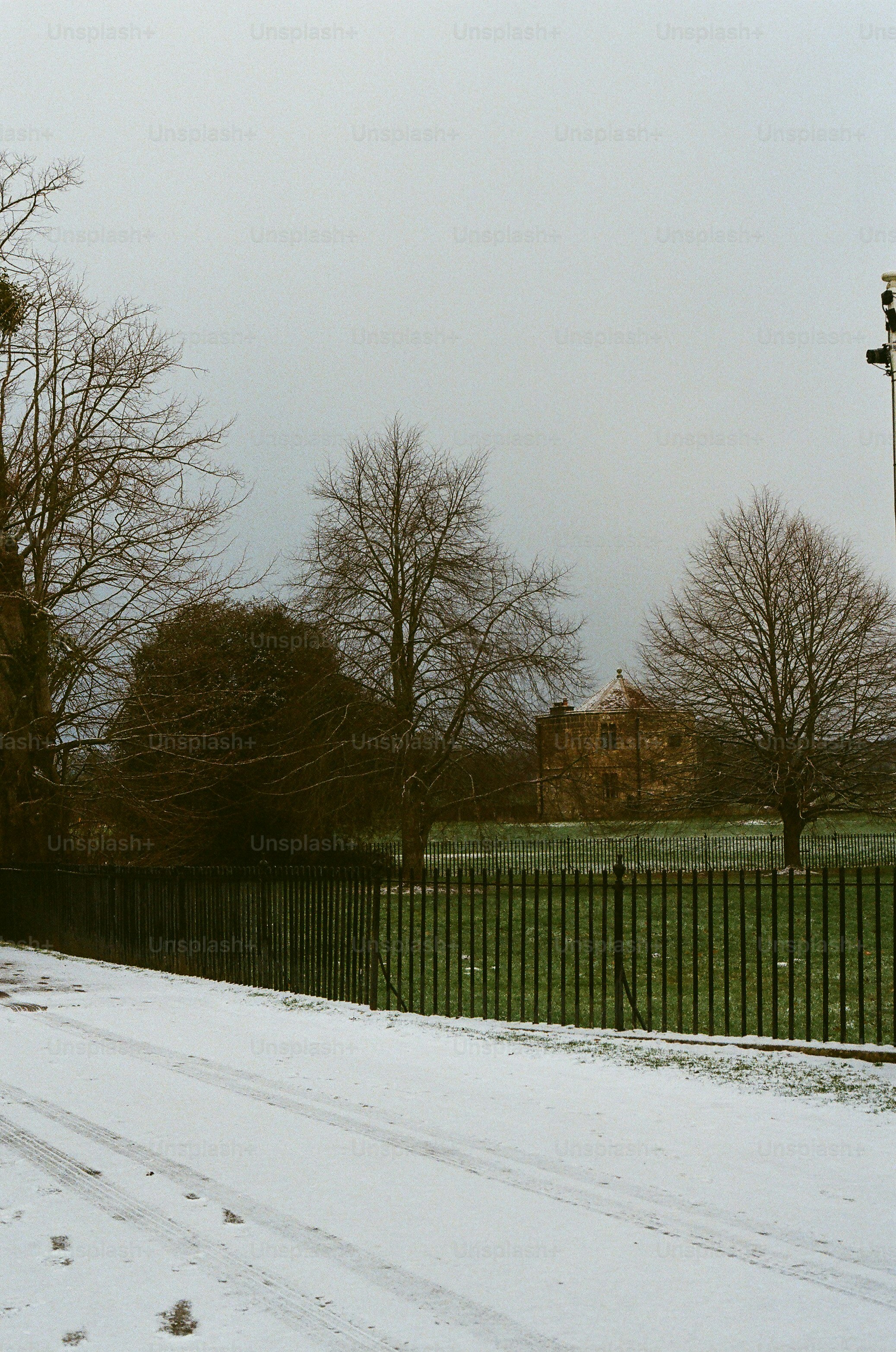 Bare trees and a stone building in snow