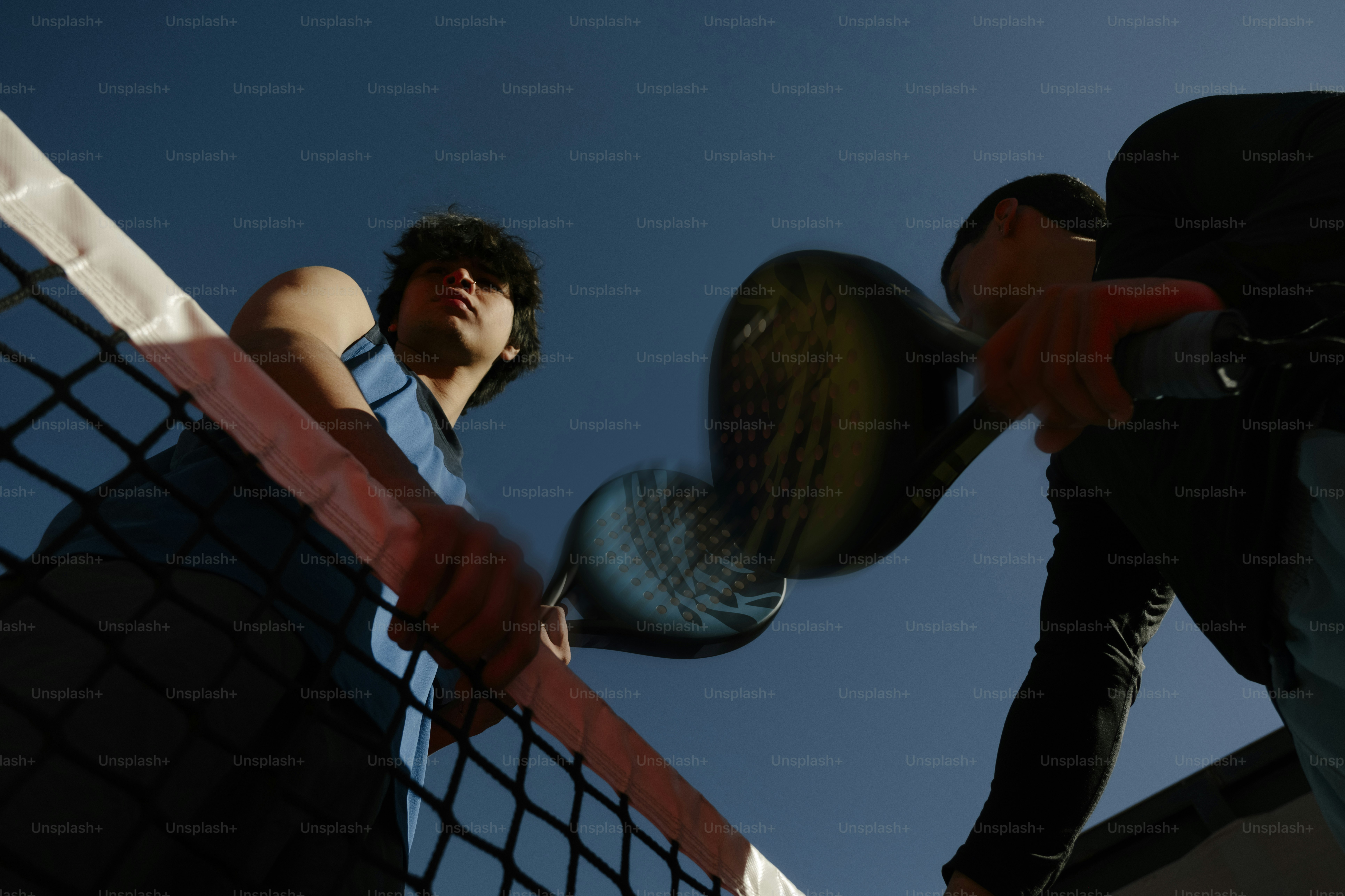 晴れた日にパドルテニスをしている二人。