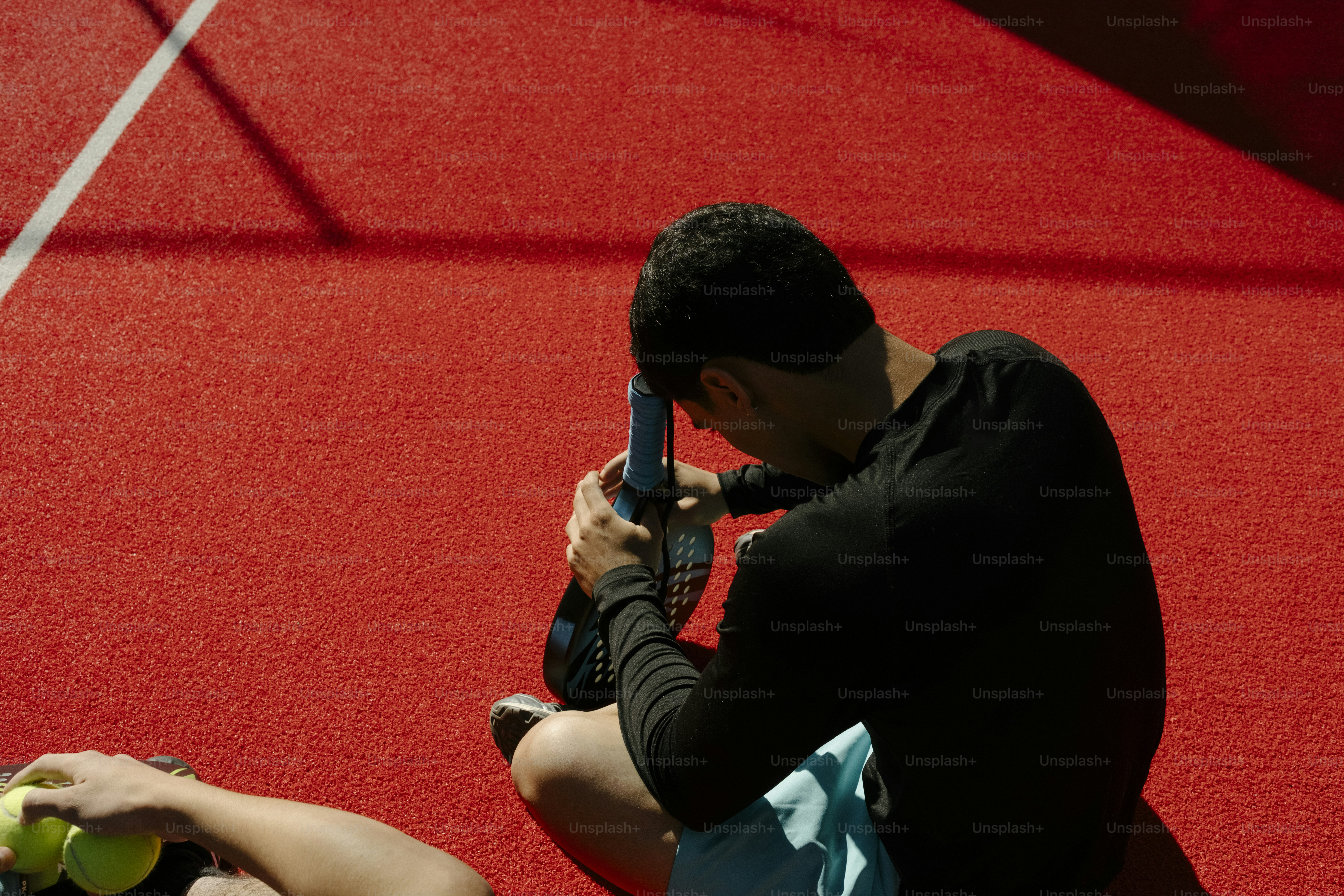 赤いコートで黒いシャツを着た男がパドルを持っている。