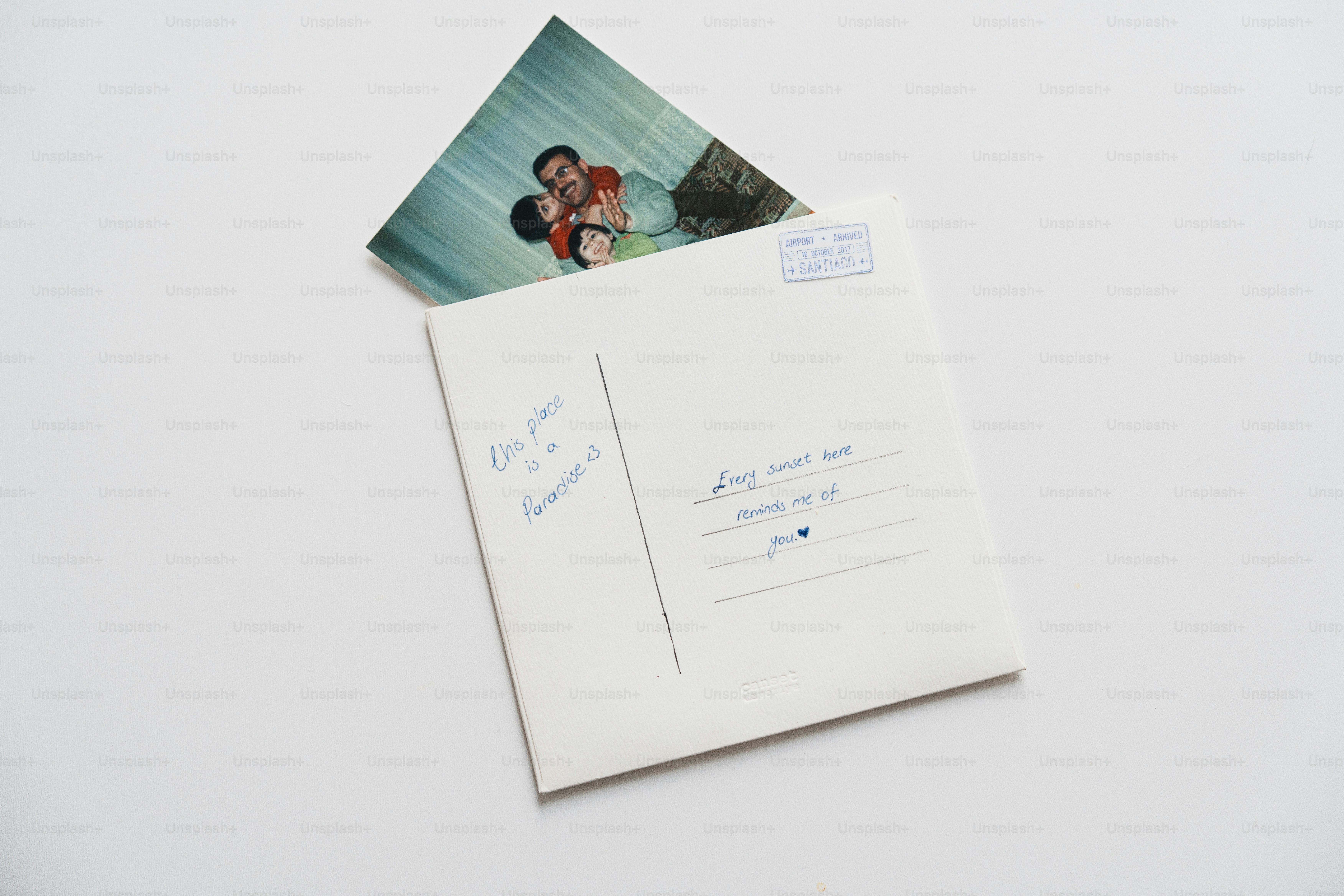 A postcard with a couple's photo peeking out from envelope