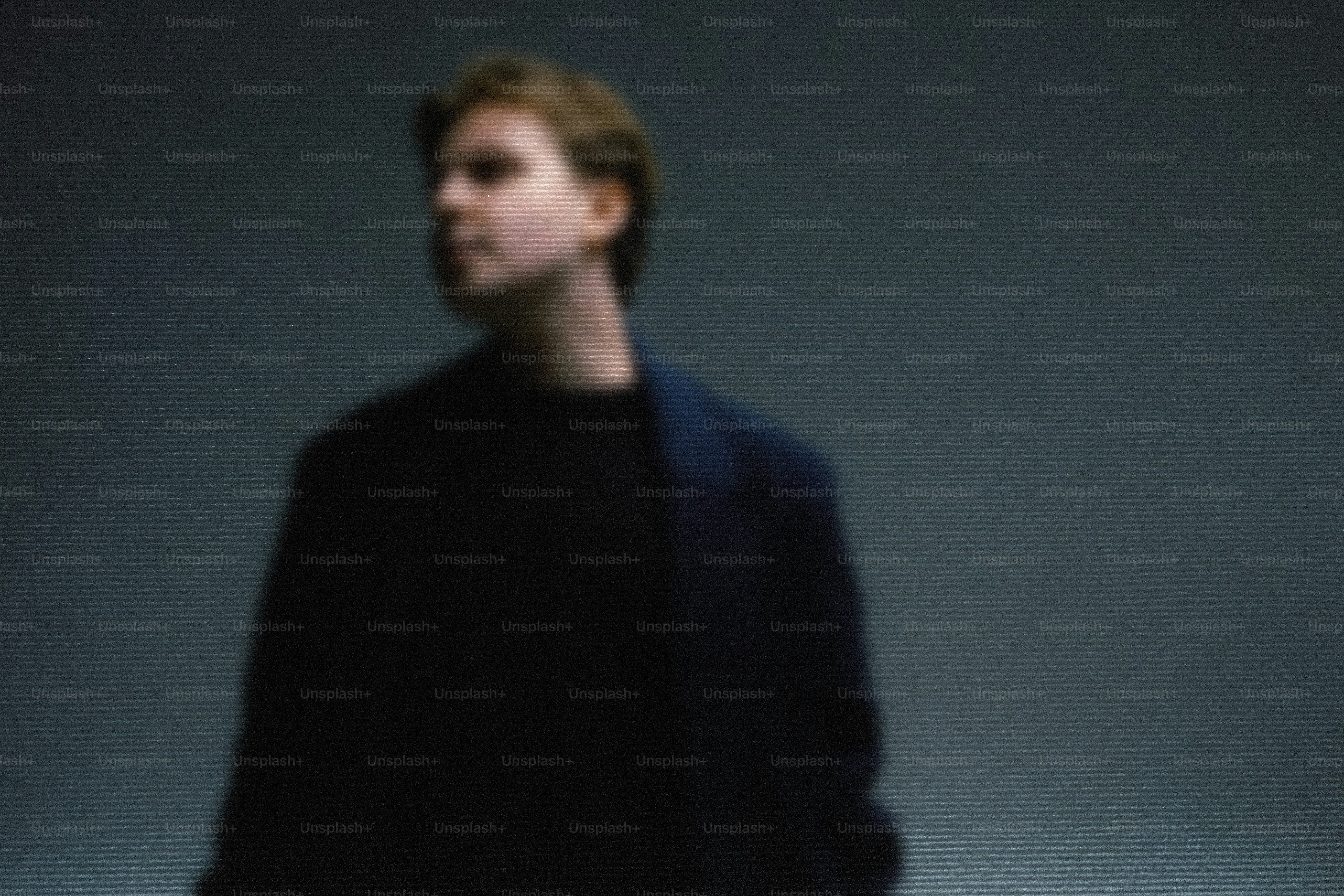 Jeune homme en vêtements sombres détournant le regard
