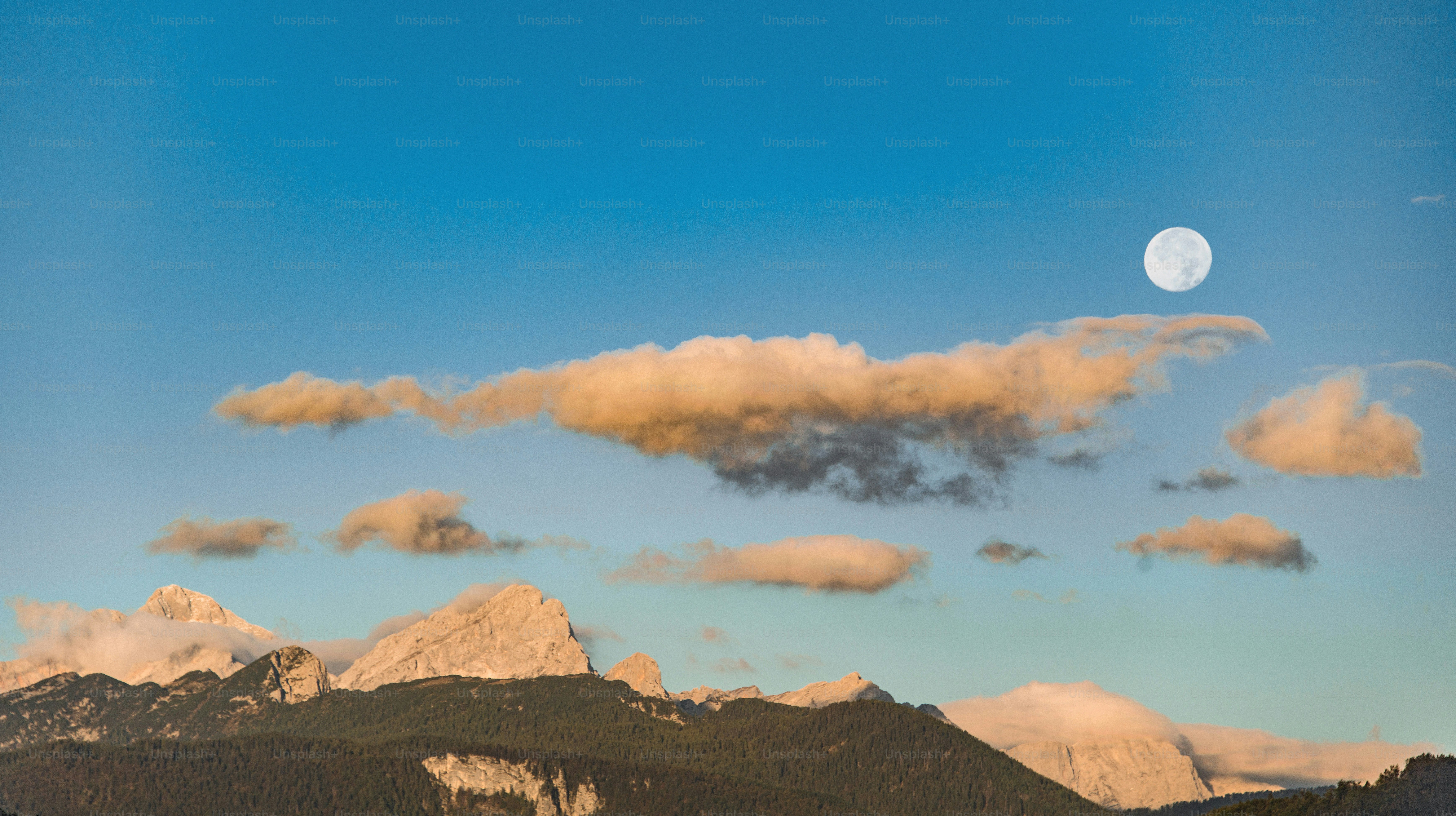 Pleine lune sur des montagnes brumeuses et des nuages
