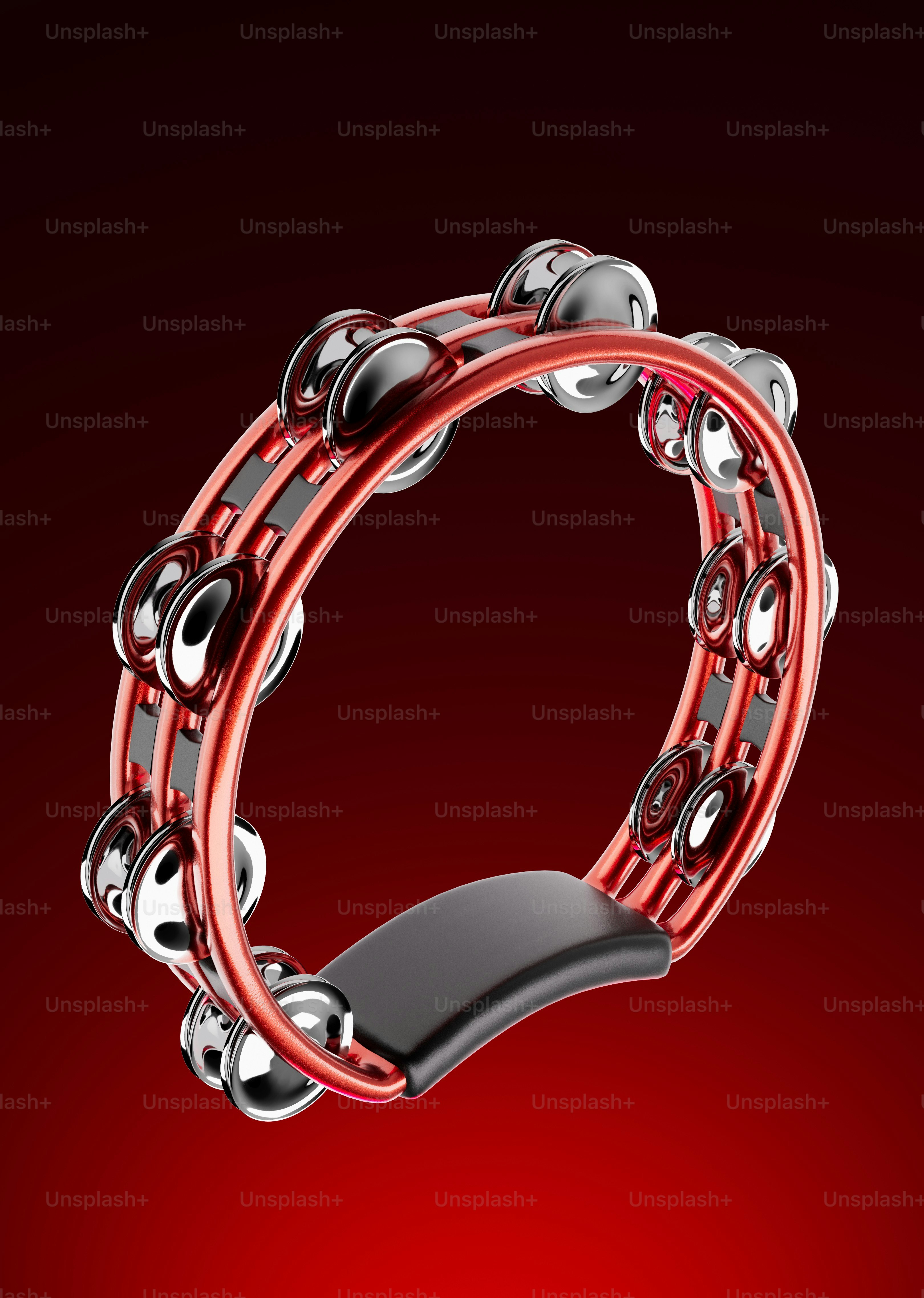 A red tambourine with silver jingles on a red background
