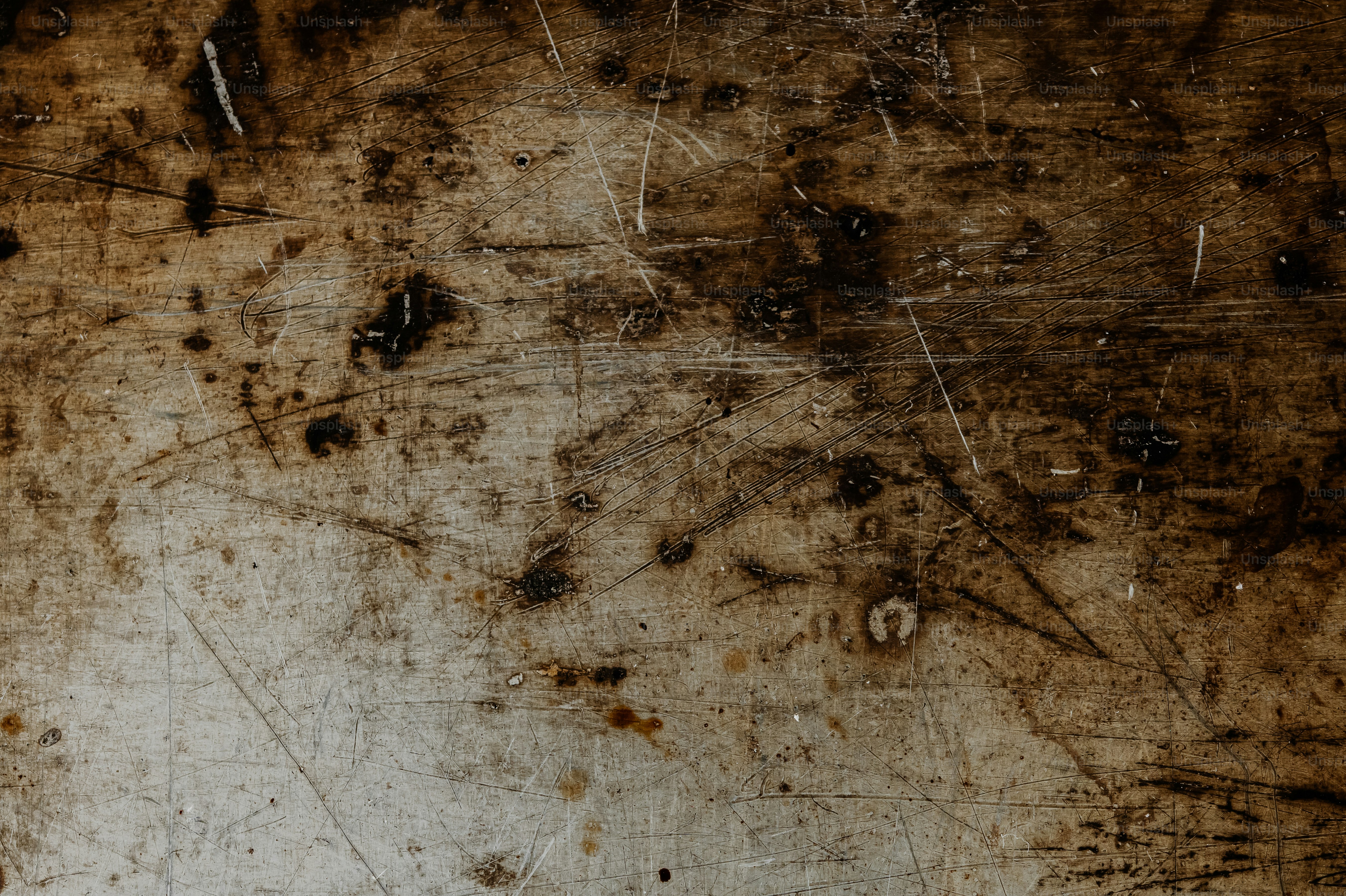 A close-up of a dirty and scratched metal surface.