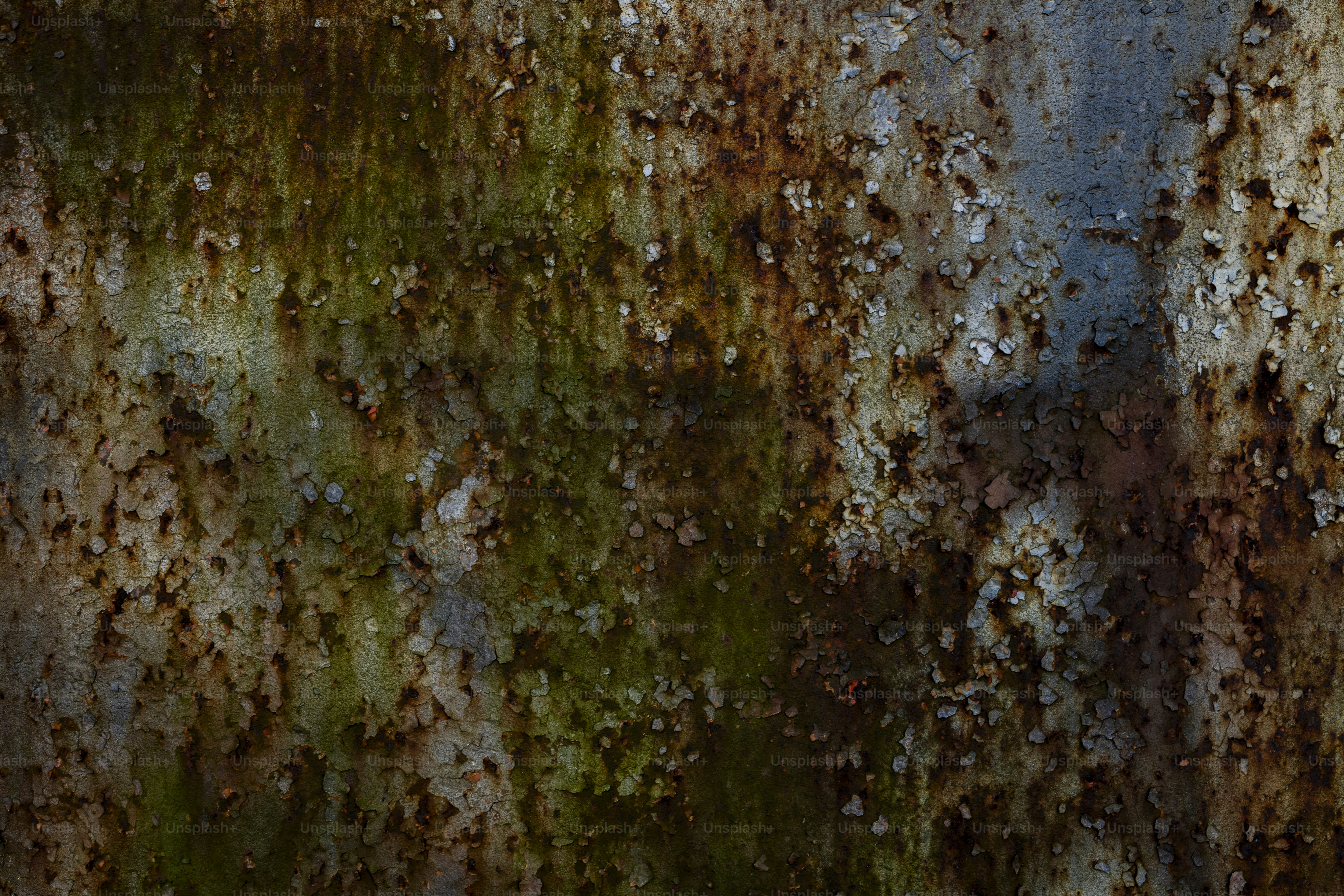 Close-up logam lapuk dan berkarat dengan lumut hijau.