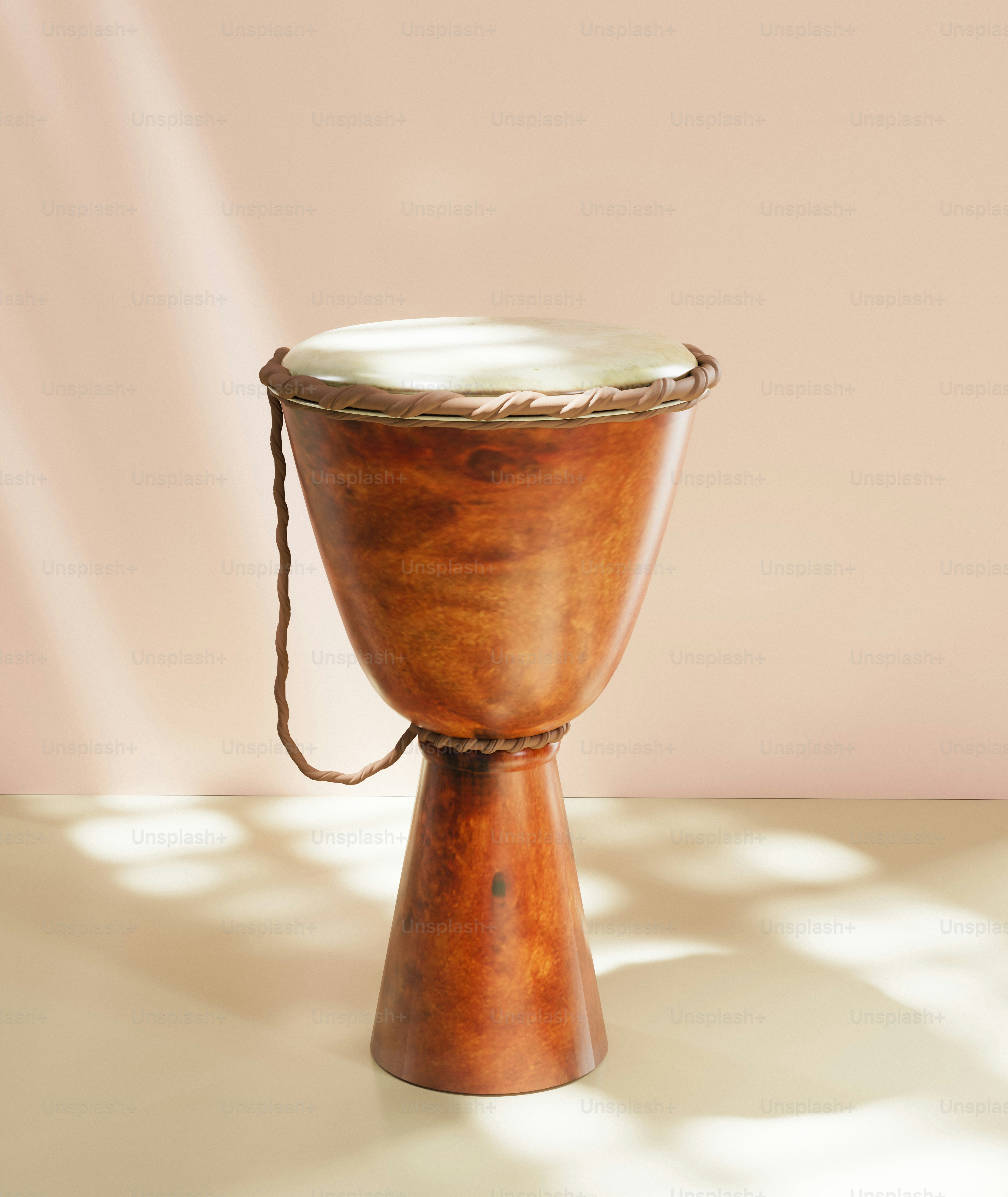 A wooden djembe drum on a light pink background.