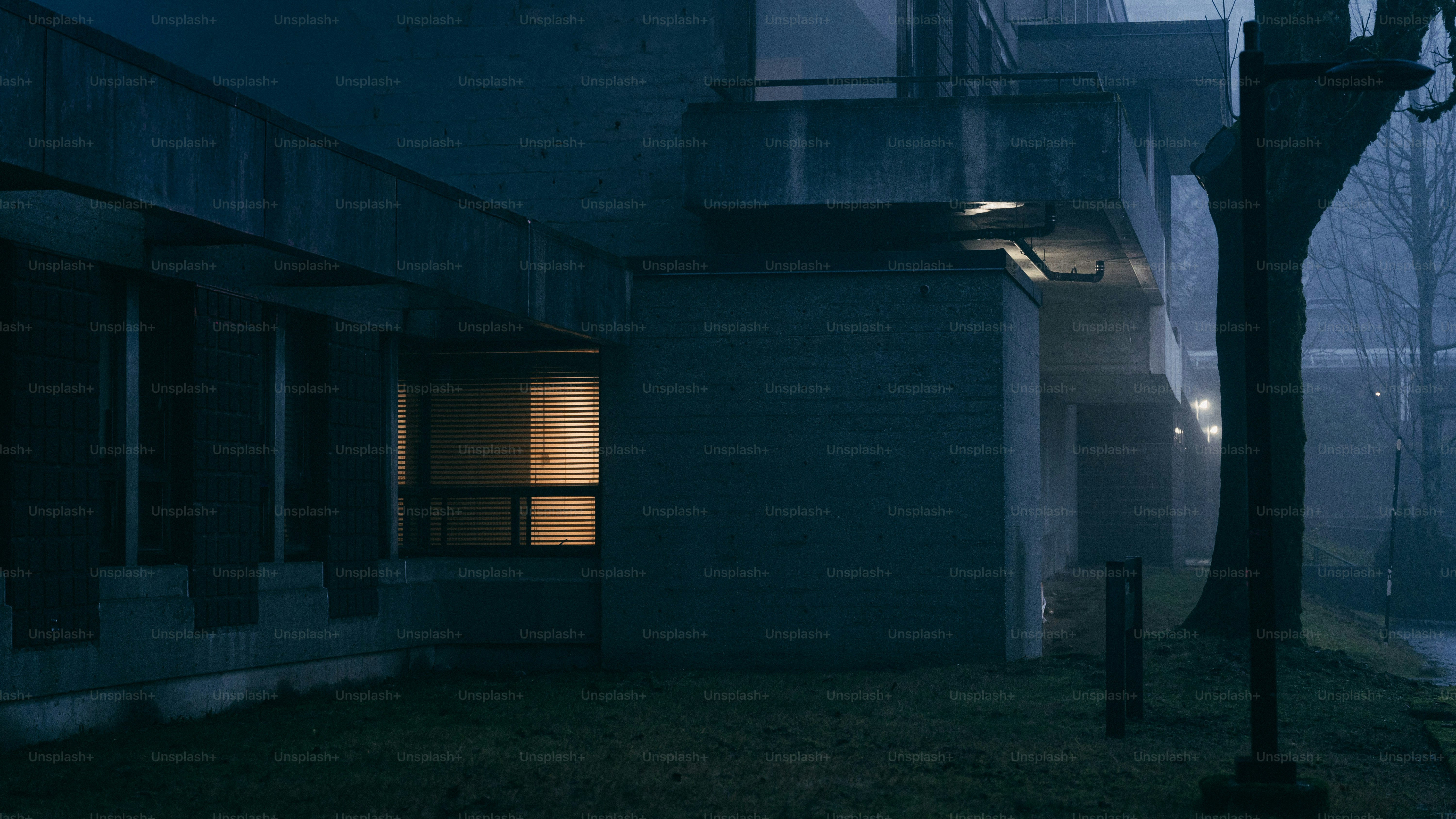 A dimly lit building exterior at night with fog.