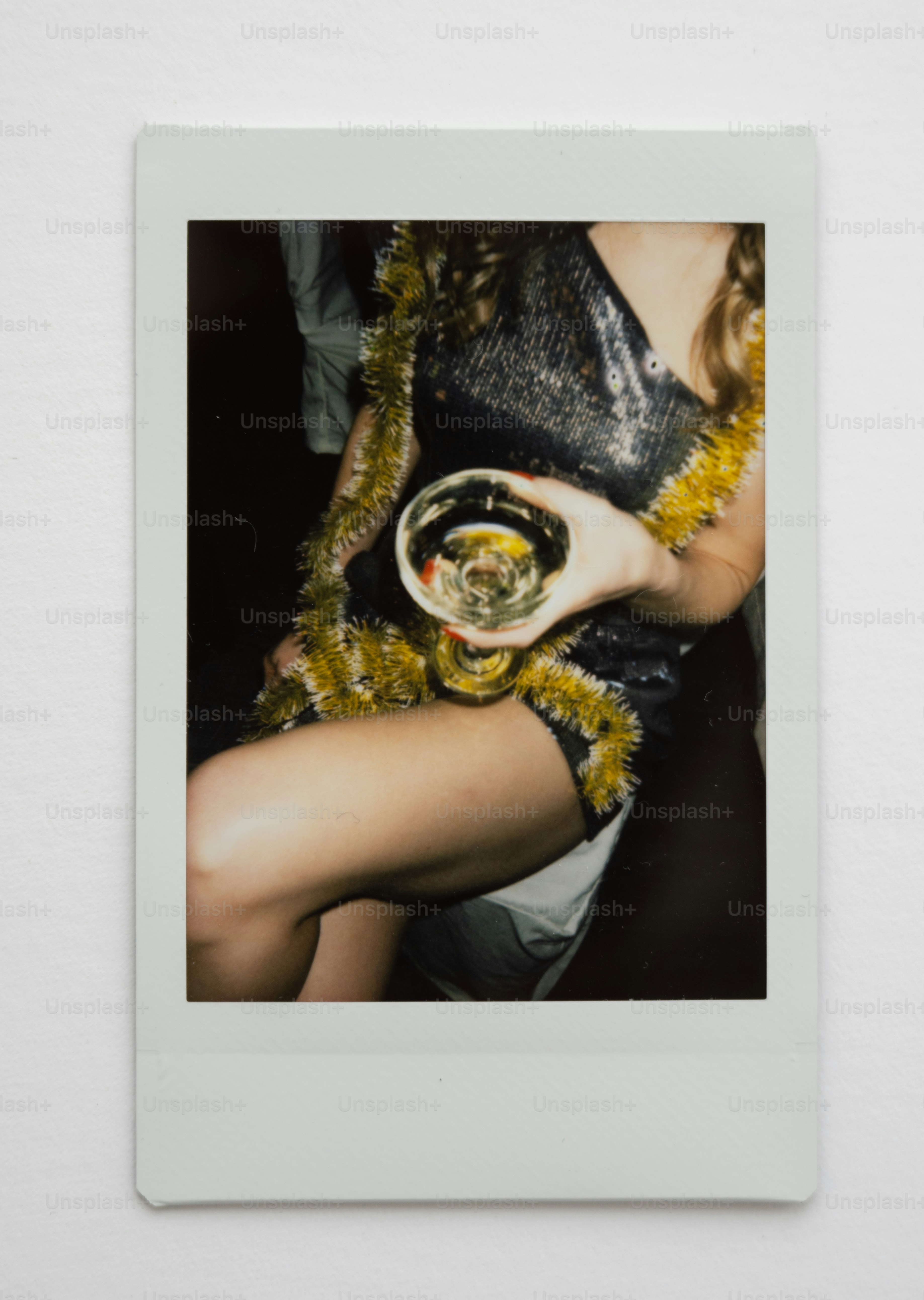 Woman in sparkly dress holding a drink at party