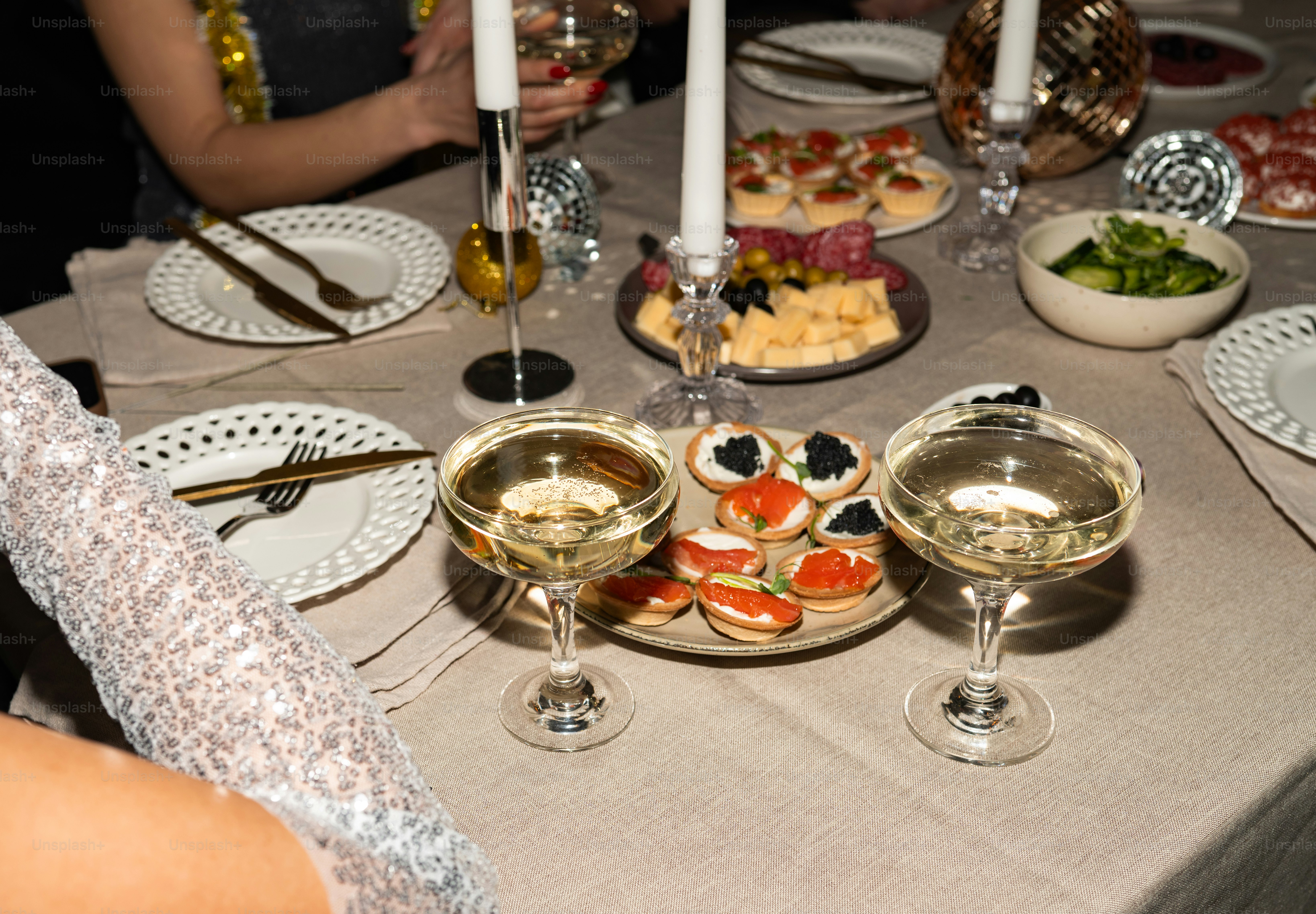 Champagne glasses and appetizers on a decorated table.