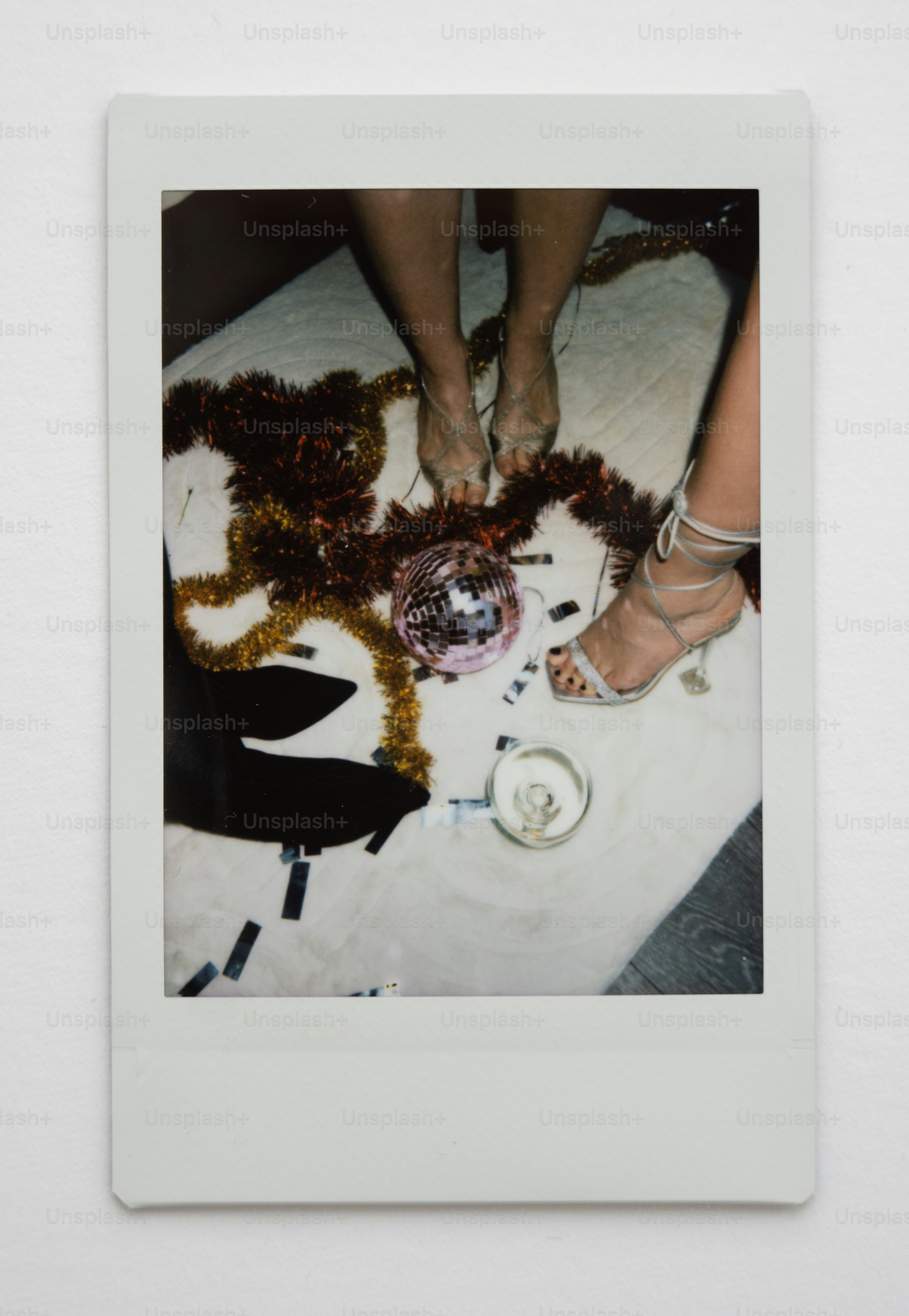 Feet in heels near disco ball and tinsel