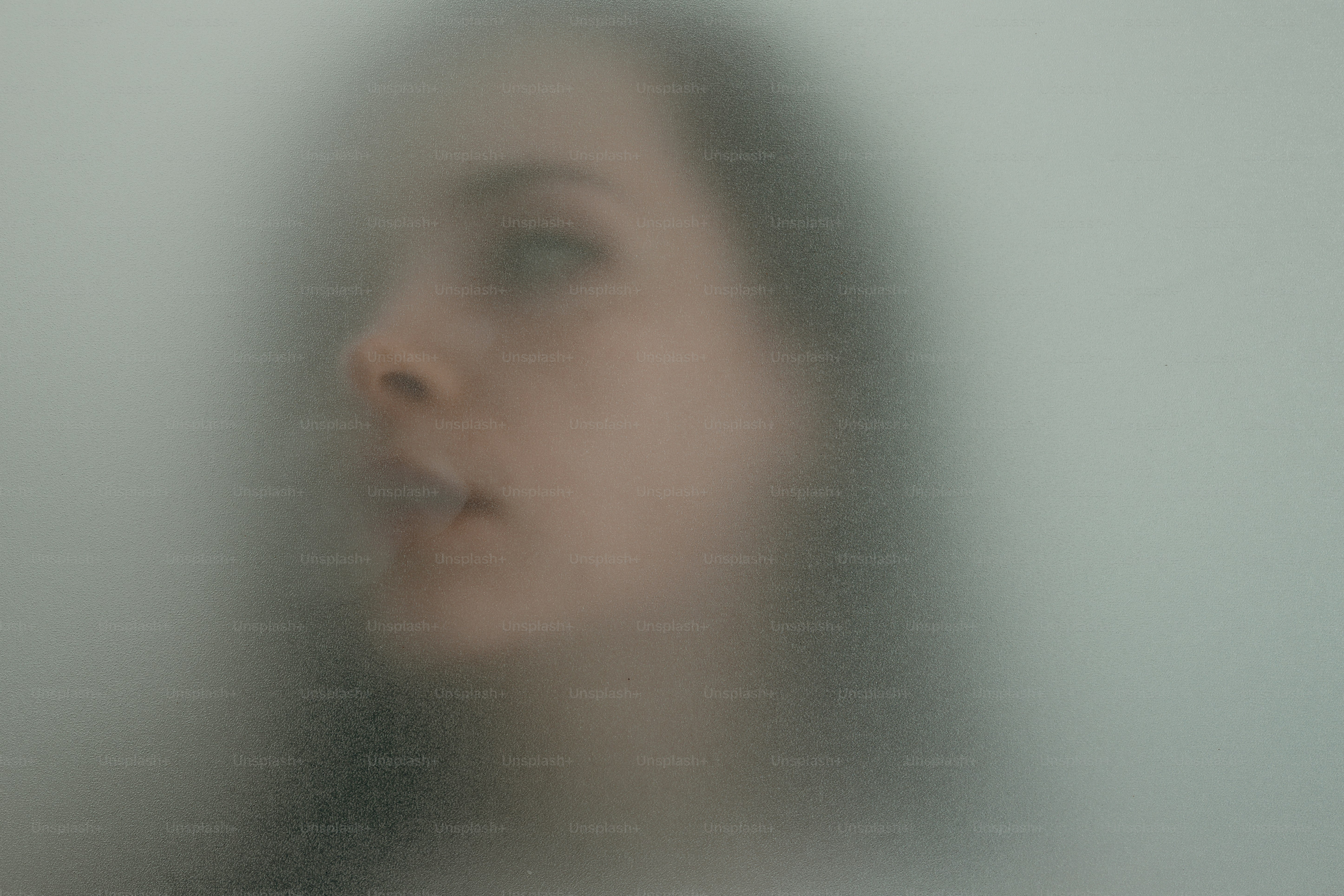 A woman's face seen through frosted glass